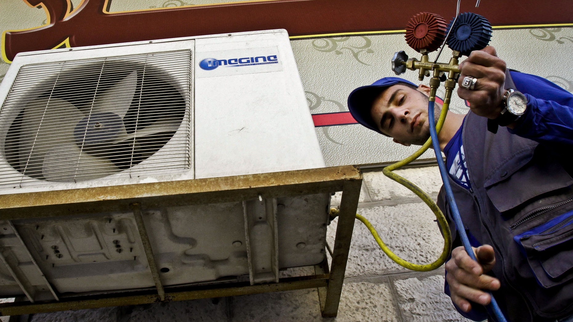 Mohammed Nabouti, a 21-year-old technician, fixes the air conditioner of a shop in Amman, Jordan on Monday, March 4, 2013. Just six months of learning to fix air conditioners changed Nabouti's life. Instead of drifting after high school like many of his jobless friends, Nabouti has taken a small loan to start his own business and recently got engaged. Nabouti's story points to a quick fix the unemployment-stricken Middle East might try until deeper economic reforms can kick in, experts say. This quick fix includes job training, micro loans and help in setting up businesses. (AP Photo/Raad Adayleh)