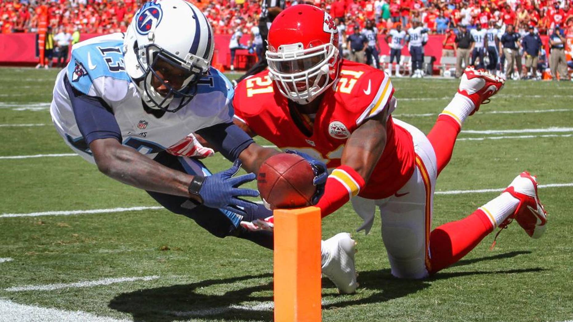 Tennessee Titans wide receiver Kendall Wright (13) scores a touchdown in front of Kansas City Chiefs cornerback Sean Smith (21) in the second half of an NFL football game in Kansas City, Mo., Sunday, Sept. 7, 2014. (AP Photo/Ed Zurga)
