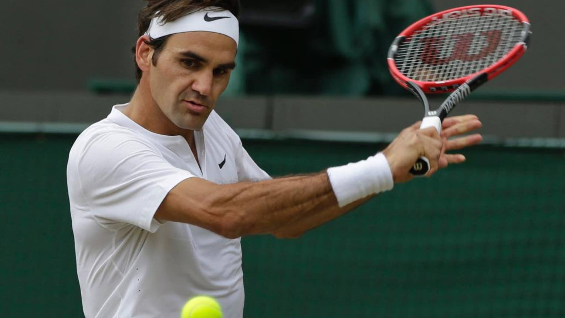 Roger Federer of Switzerland plays a return to Gilles Simon of France during the men's quarterfinal singles match at the All England Lawn Tennis Championships in Wimbledon, London, Wednesday July 8, 2015. (AP Photo/Pavel Golovkin)