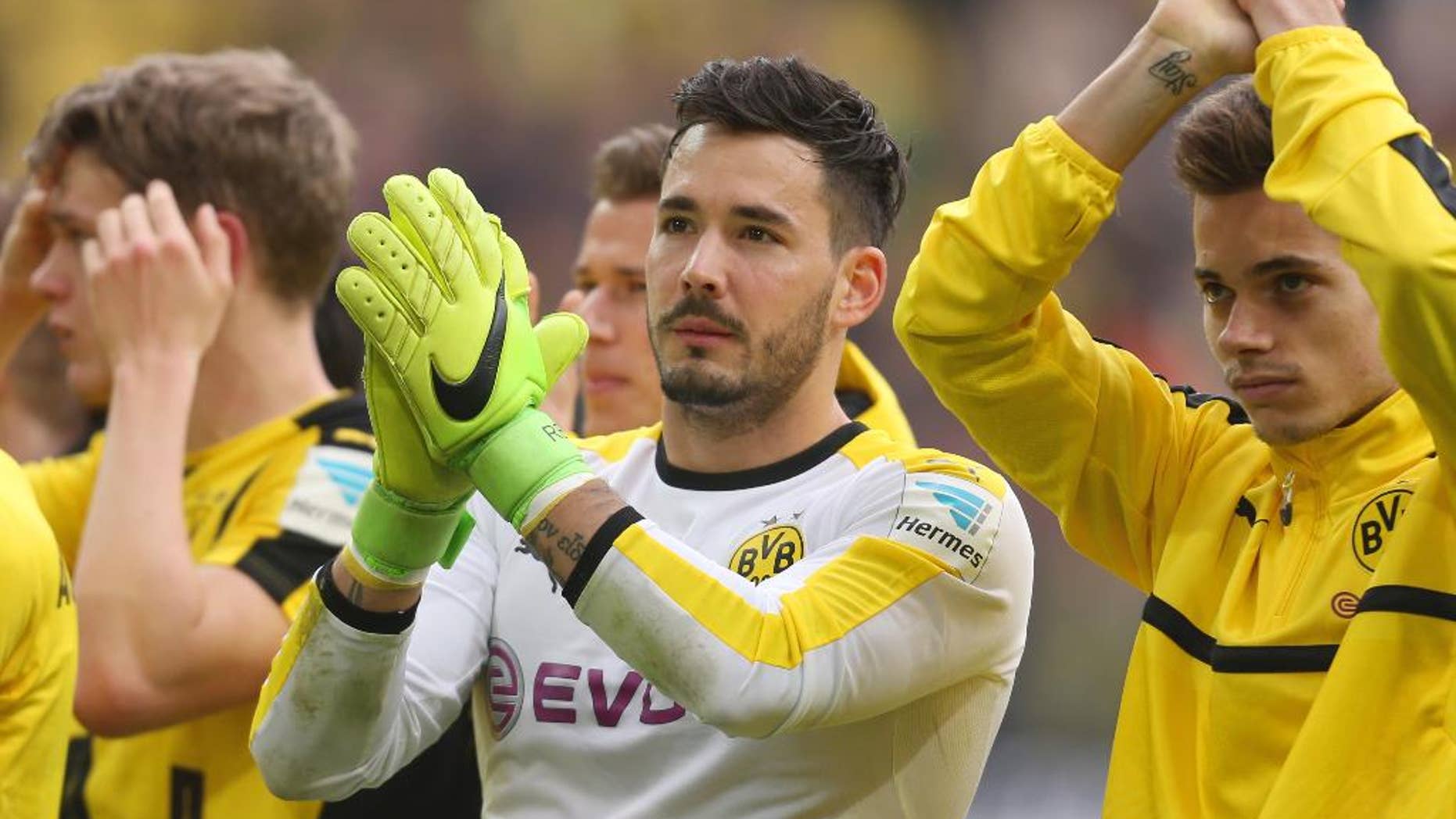 FILE - In this April 15, 2017 photo Dortmund's goalkeeper Roman Buerki und Raphael Guerreiro, right, cheer towards their fans after the German Bundesliga soccer match between Borussia Dortmund and Eintracht Frankfurt in Dortmund, Germany. Borussia Dortmund goalkeeper Roman Buerki says he’s still having trouble sleeping after the attack on his team’s bus on April 11, and says he couldn’t concentrate properly in the delayed Champions League match a day later. (Ina Fassbender/dpa via AP,file)