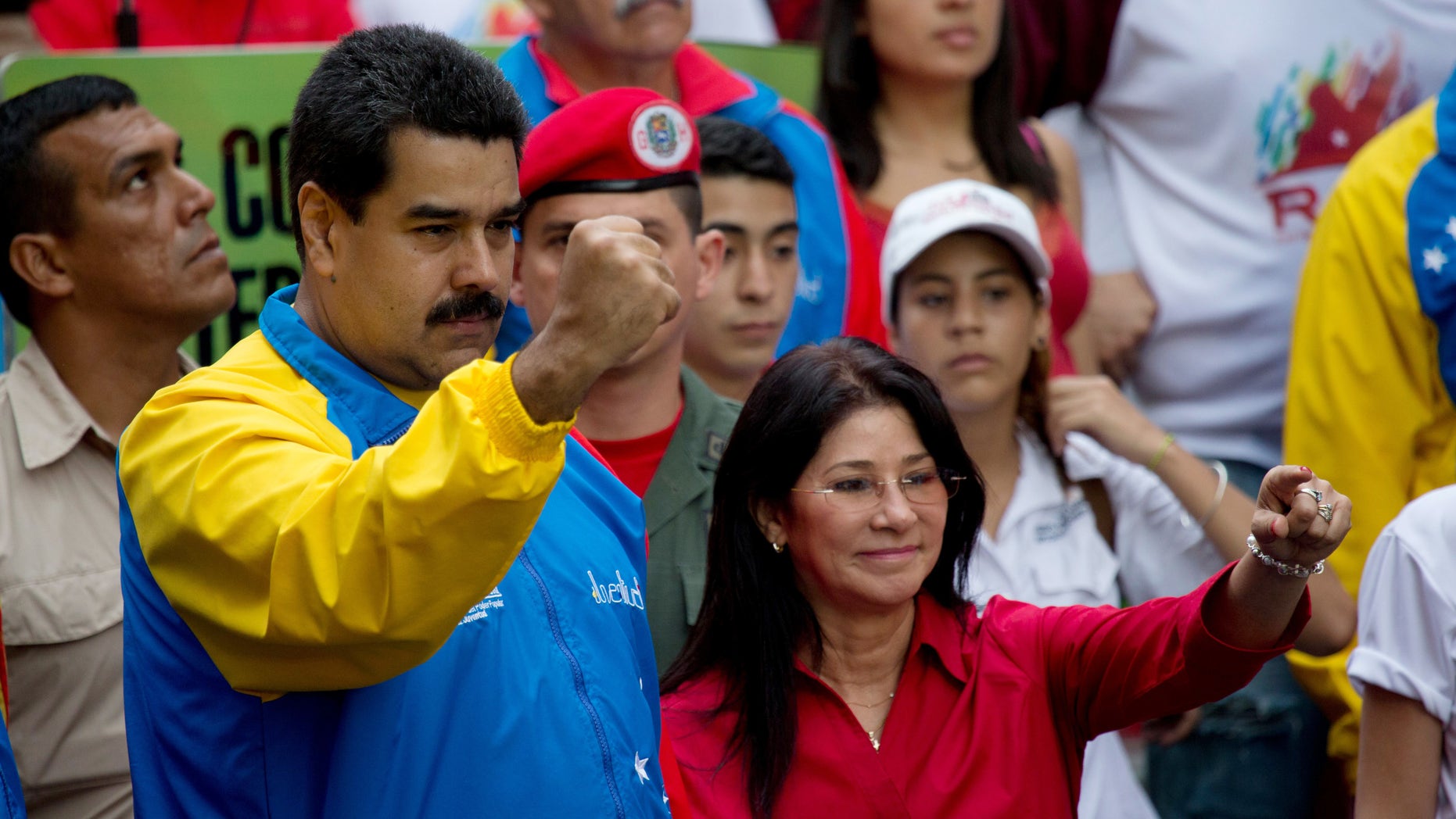 FILE - In this Oct. 18, 2014 file photo, Venezuela's President Nicolas Maduro and first lady Cilia Flores, greet supporters as they arrive for a march for peace in Caracas, Venezuela. Two nephews of Venezuela's powerful first lady Cilia Flores were arrested in Haiti on charges of conspiring to smuggle 800 kilograms of cocaine into the U.S. and will be arraigned in New York, three people familiar with the case said Wednesday, Nov. 11, 2015. (AP Photo/Fernando Llano, File)