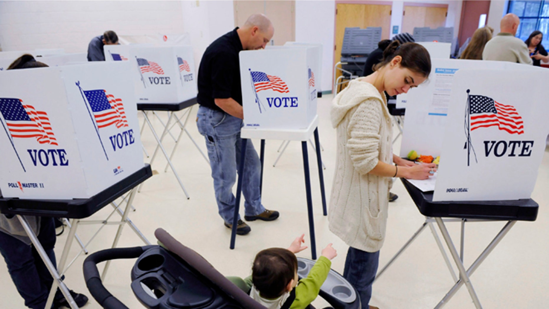 CENTRAL CITY, CO - NOVEMBER 2: Mica Rickman, 1, reaches out to his mother, Carly Fridlich as she votes at the Gilpin County Community Center on November 2, 2010 outside of Central City, Colorado. Coloradians are going to the polls to decide a Governor's race as well as a hotly contested Senatorial race between Democratic U.S. Sen. Michael Bennet (D-CO) and Republican Ken Buck. (Photo by Matt McClain/Getty Images)