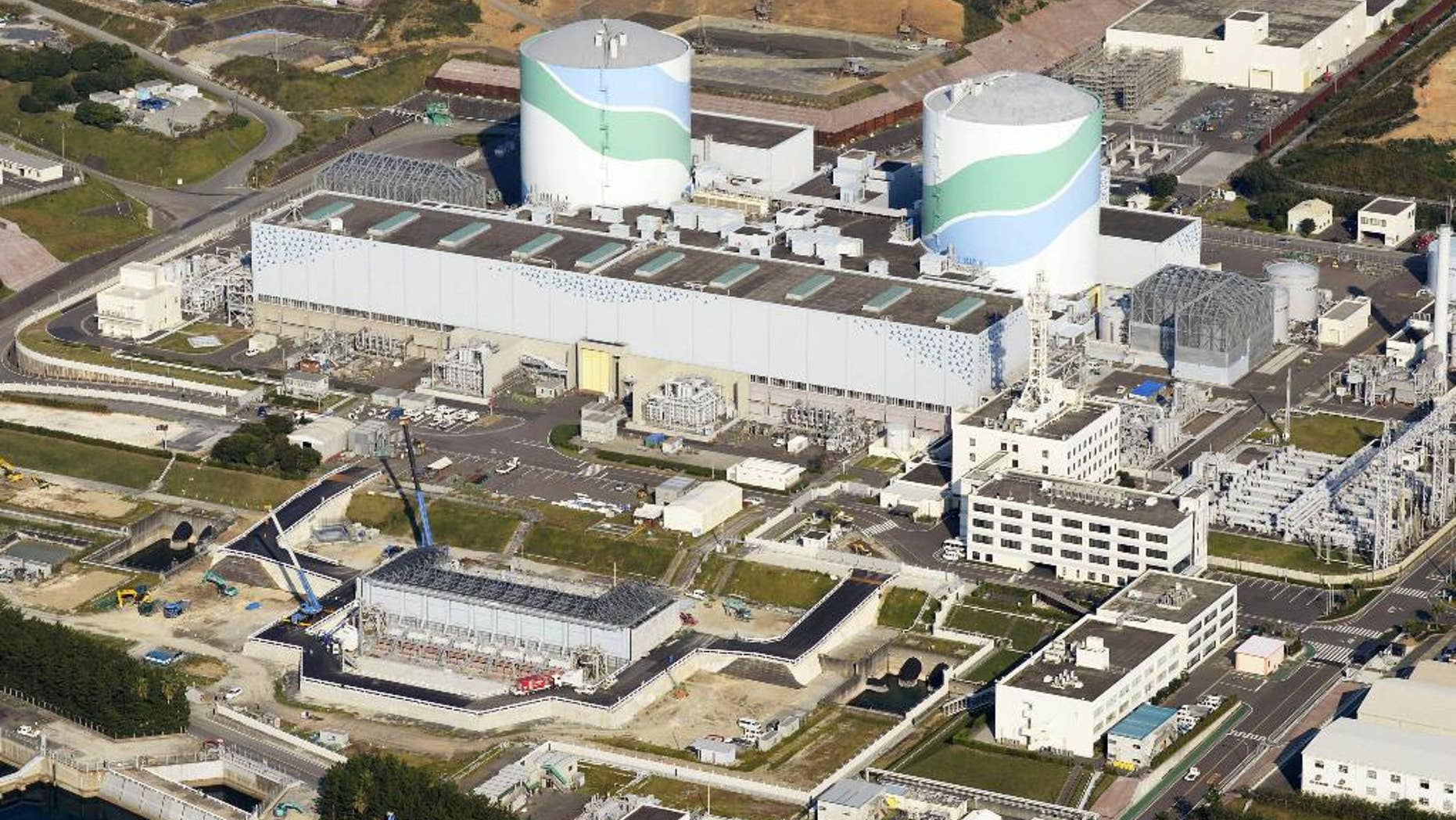 FILE - This Oct. 24, 2014 aerial photo shows two reactors at the Sendai Nuclear Power Station in Satsumasendai, Kagoshima prefecture, southern Japan. The nuclear plant on Wednesday, May 27, 2015 obtained the final permit needed to restart its reactors, paving the way for it to become the first to go back online under new safety standards introduced following the 2011 Fukushima disaster. The two reactors at the nuclear power station would mark the country’s return to nuclear energy, as Prime Minister Shinzo Abe’s pro-business government tries to put as many reactors back on-line as possible. (Kyodo News via AP, File) JAPAN OUT, CREDIT MANDATORY