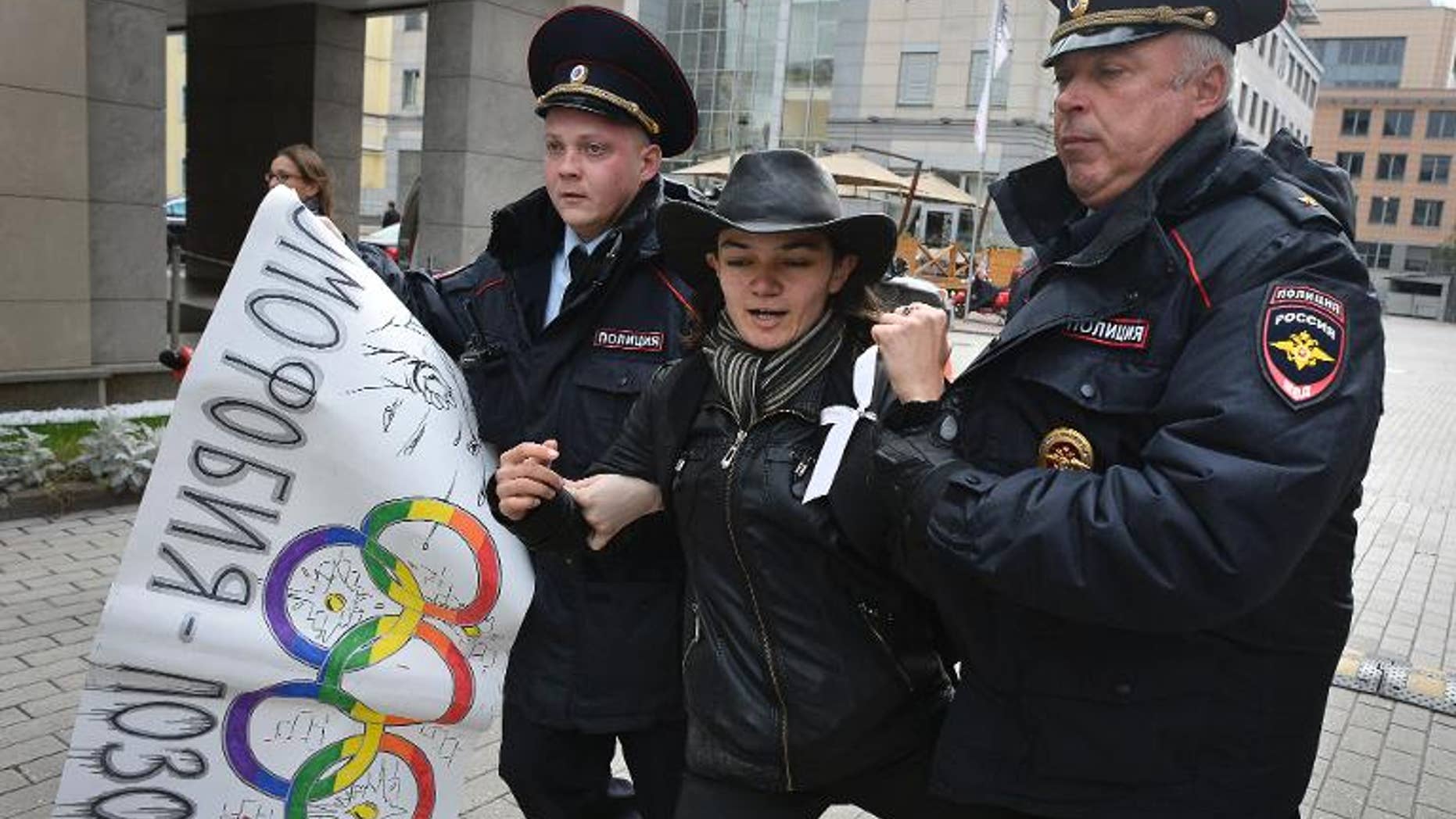 Police detain a gay rights activist outside the headquarters of the Sochi 2014 Organizing Committee in Moscow on September 25, 2013