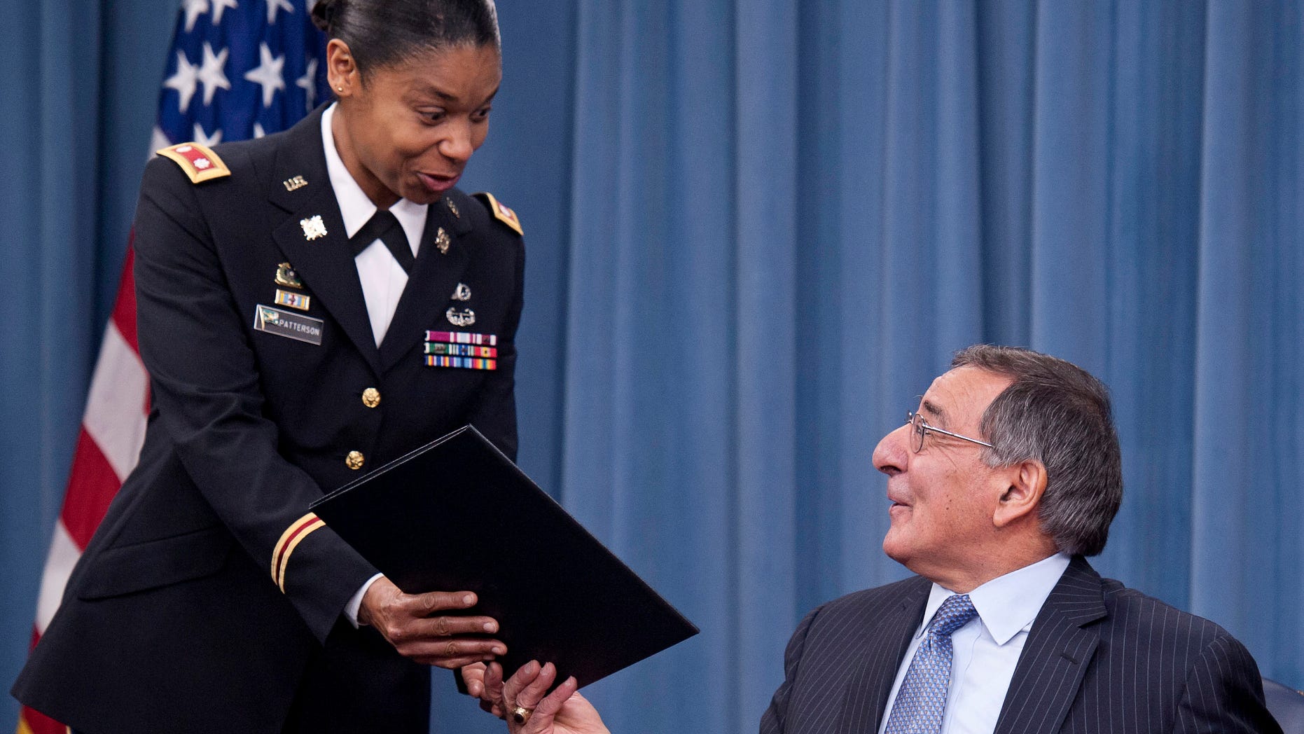 FILE – in this Jan. 24, 2013, file photo Secretary of Defense Leon Panetta hands the memorandum he has just signed, ending the 1994 ban on women serving in combat, to Army Lt. Col. Tamatha Patterson of Huntingdon, Tenn., during a press briefing at the Pentagon in Arlington, Va., Thursday, Jan. 24, 2013. The decision to lift the ban on women in combat has opened the door for a change in the law that currently compels only men between the ages of 18 and 25 to register for a military draft, according to legal experts and military historians. (AP Photo/Cliff Owen, file)