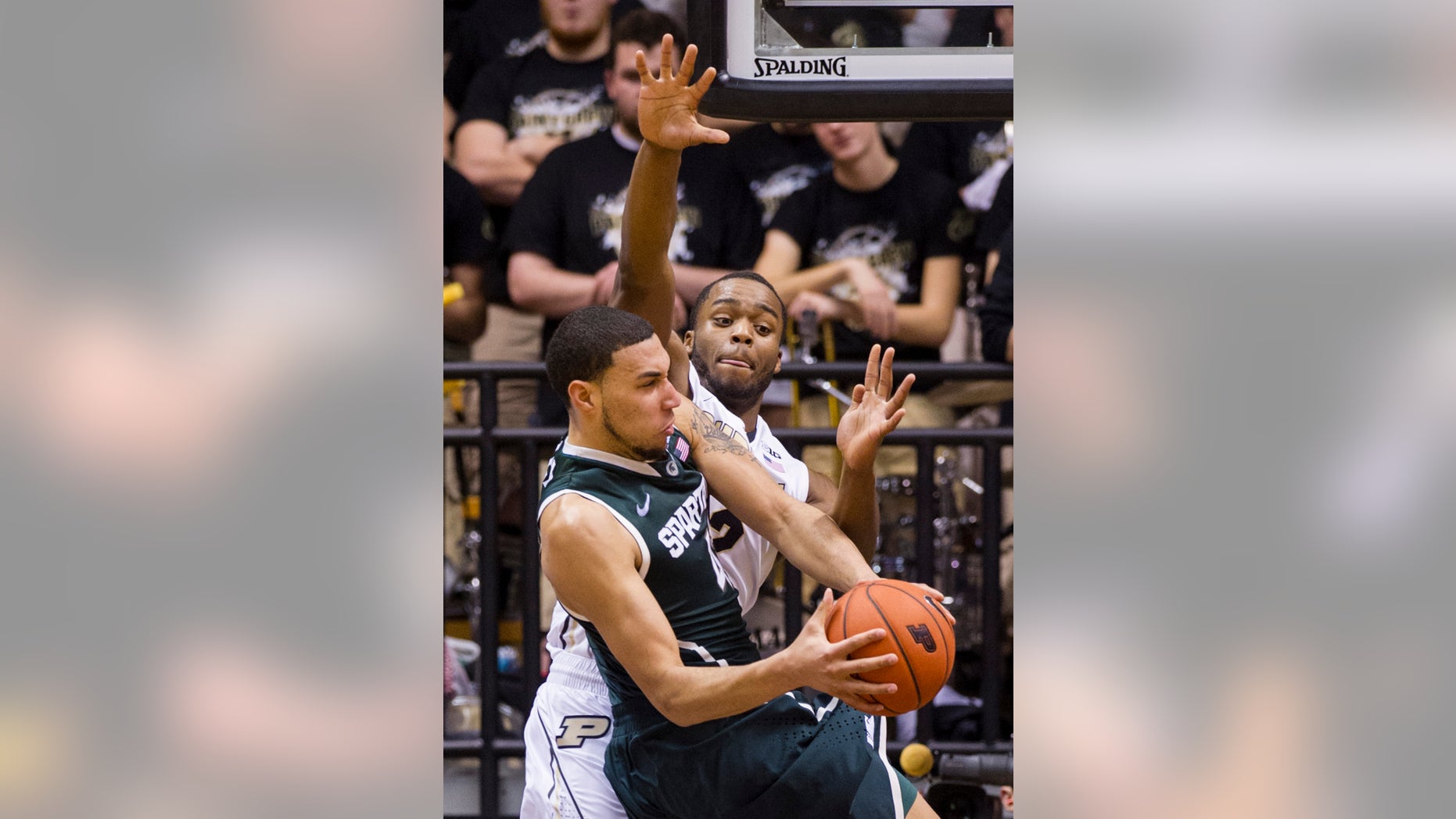 Purdue’s Errick Peck (32) goes up in an attempt to block the shot of Michigan State’s Denzel Valentine (45) in the second half of an NCAA college basketball game, Thursday, Feb. 20, 2014, in West Lafayette, Ind. Michigan State defeated Purdue 94-79. (AP Photo/Doug McSchooler)