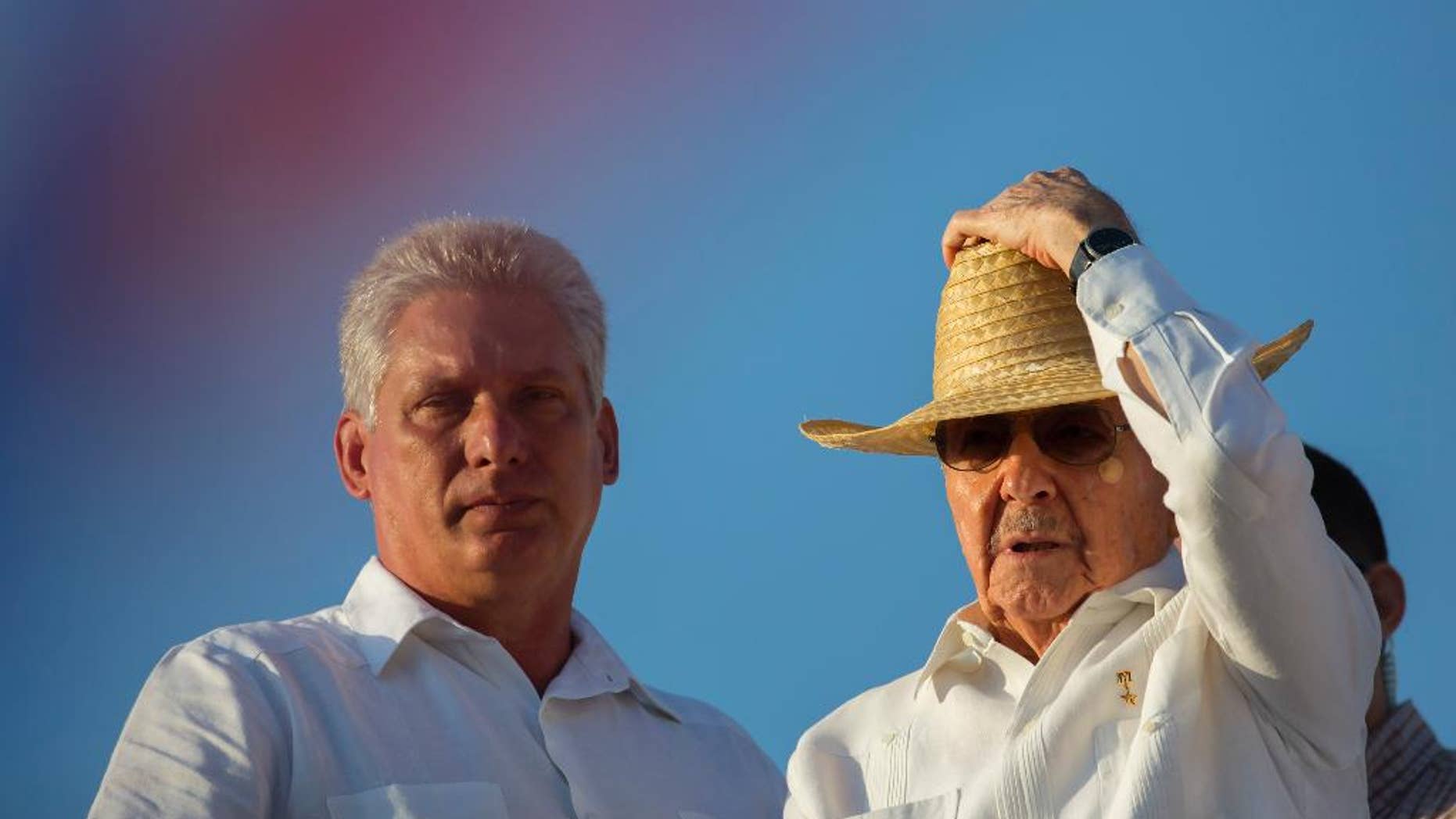 FILE - In this May 1, 2016 file photo, Cuba's First Vice President Miguel Diaz-Canel, left, stands with President Raul Castro during the May Day parade in Havana, Cuba. Diaz-Canel, an engineer by training who began his career as a provincial bureaucrat, is expected in 2018 to assume one of Raul Castro’s roles: the presidency. Castro plans to remain first secretary of the Cuban Communist Party, a potentially more powerful position, until at least 2021. (AP Photo/Ramon Espinosa, File)