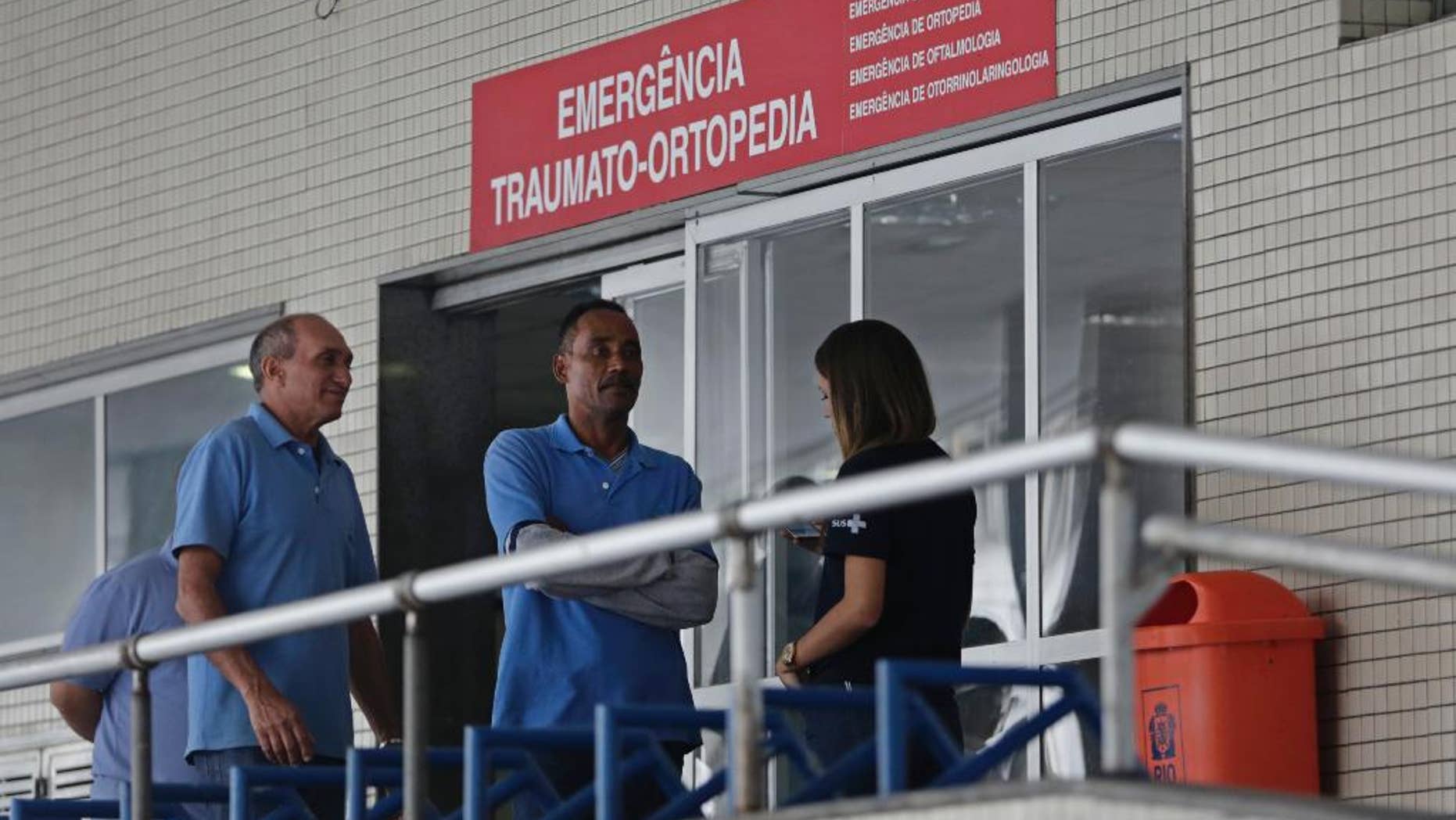 FILE - In this June 19, 2016, file photo, employees stand in front an emergency entrance at the Souza Aguiar Hospital, in Rio de Janeiro, Brazil. Brazilian police announced Monday, Sept. 26, that they have shot dead a suspected drug trafficker who stunned Rio de Janeiro by pulling off the violent escape from the hospital. (AP Photo/Silvia Izquierdo, File)