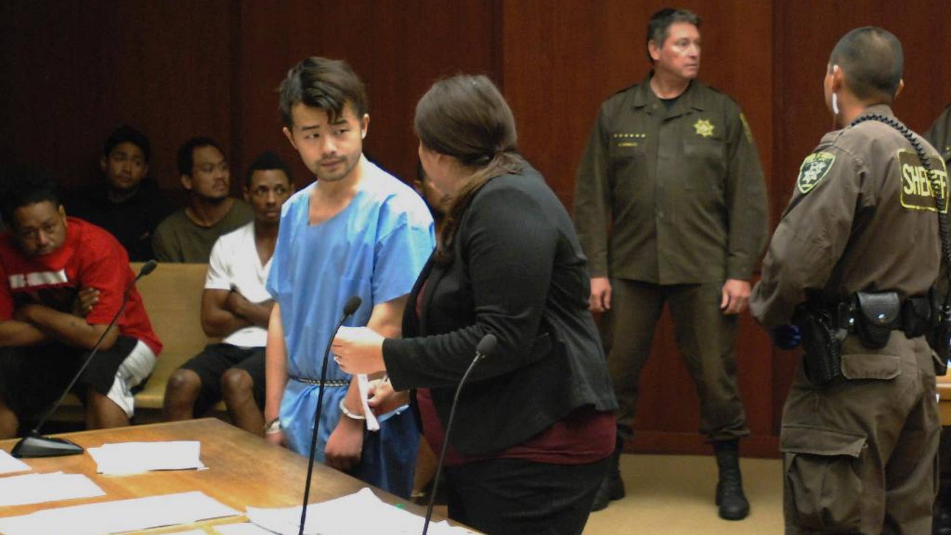 Yu Wei Gong, left, speaks to Deputy Public Defender Diamond Grace in court in Honolulu on Monday, April 17, 2017. The Hawaii man accused of killing his mother months ago stuffed her decapitated head and dismembered body parts in several plastic bags in the refrigerator freezer of the Waikiki apartment they shared, according to court documents made public ahead of the suspect's first court appearance. (AP Photo/Jennifer Sinco Kelleher)