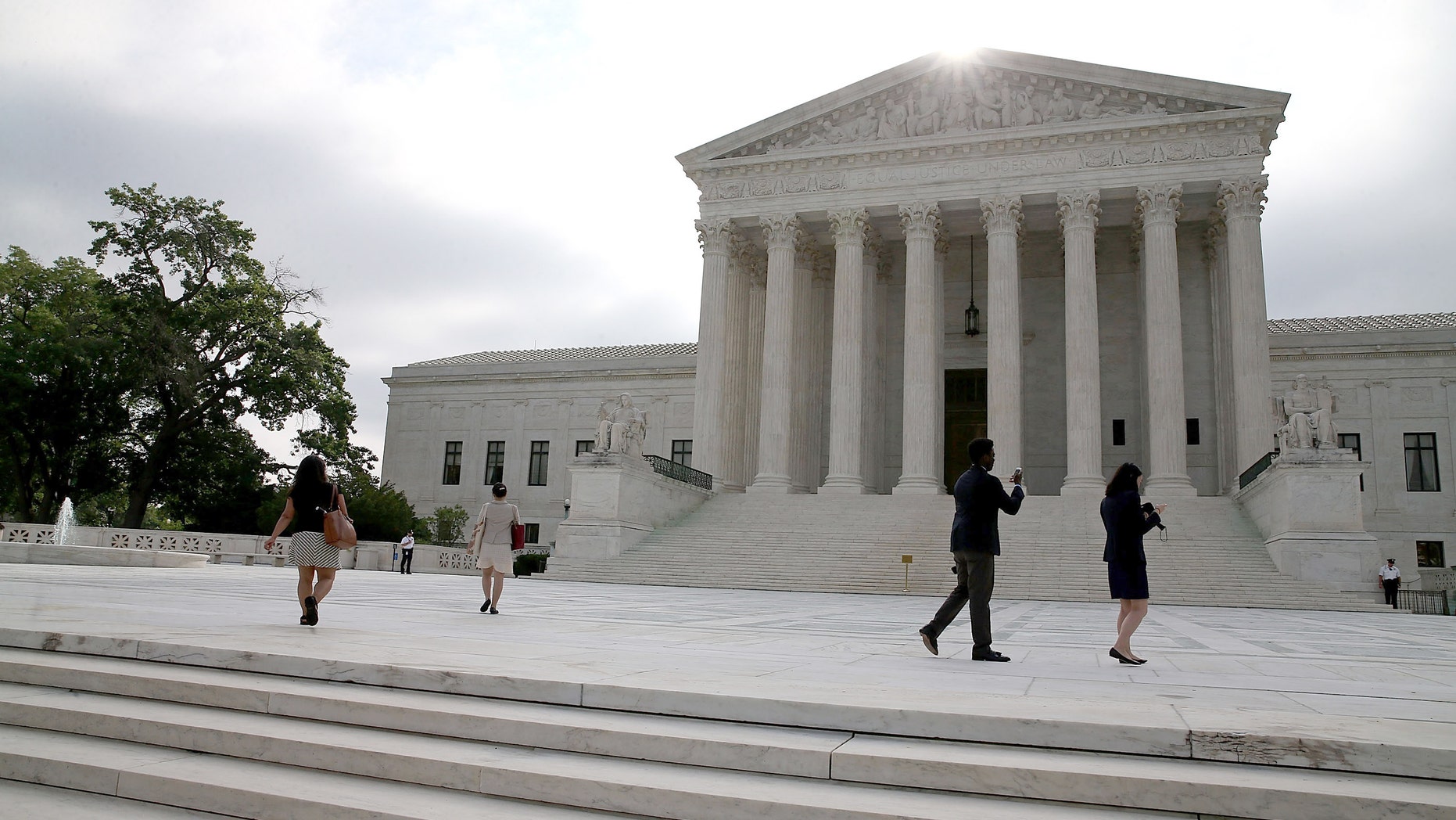 WASHINGTON, DC - JUNE 18: People gather in front of the Supreme Court Building June 18, 2015 in Washington, DC. This month the high court is expected to hand down its ruling on gay marriage and Obamacare subsidies. (Photo by Mark Wilson/Getty Images)