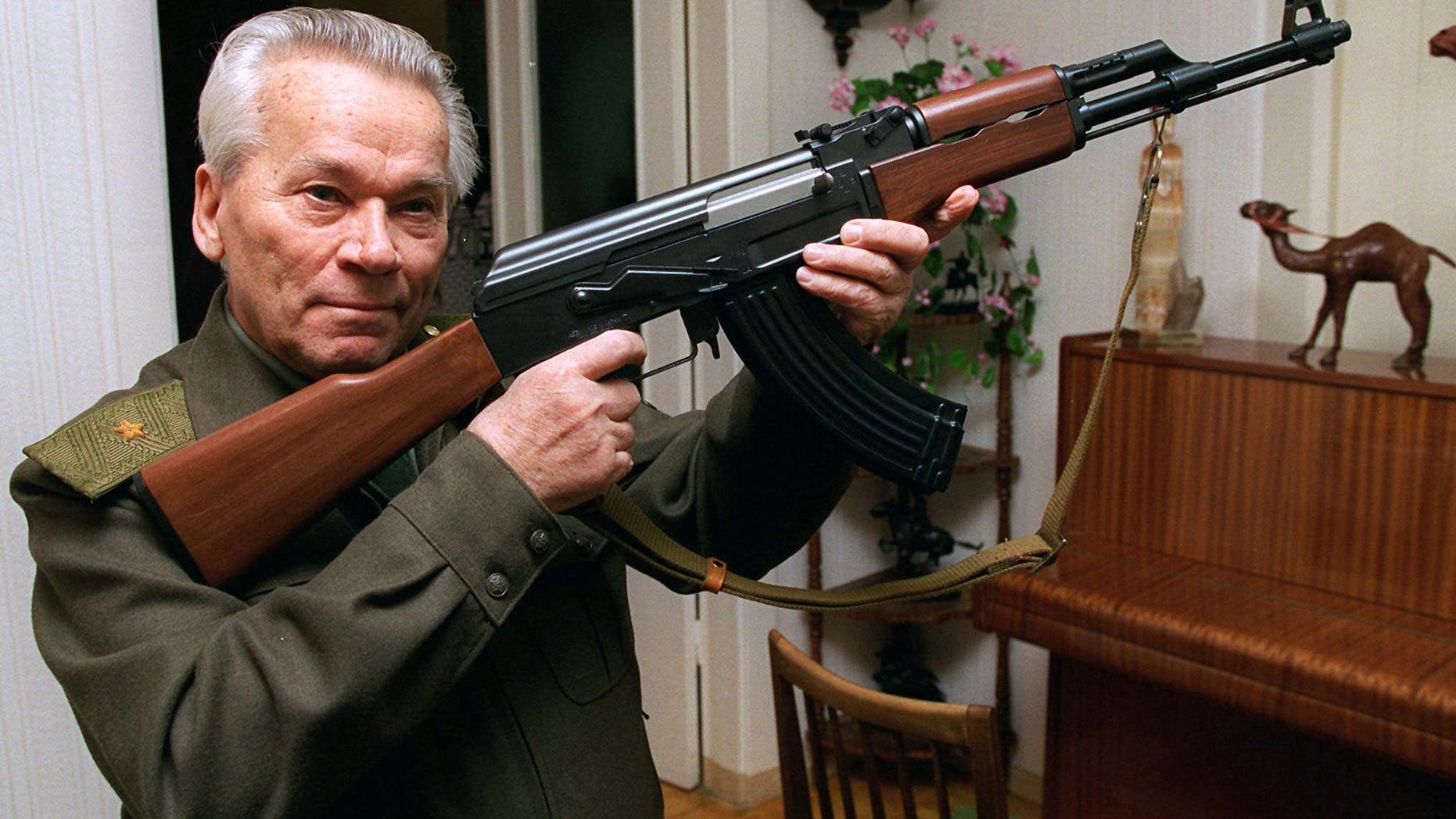FILE - In this Wednesday, Oct. 29, 1997 file photo Mikhail Kalashnikov shows a model of his world-famous AK-47 assault rifle at home in the Ural Mountain city of Izhevsk, 1000 km (625 miles) east of Moscow. The designer of the world’s most prolific firearm, the AK-47 assault rifle, has written a sorrowful letter to the Russian Orthodox Church’s head, asking if he’s to blame for the deaths of those killed by his creation. According to a Monday, Jan. 13, 2014 report in the daily Izvestia, several months before his death last month at age 94, Kalashnikov wrote to Patriarch Kirill that he keeps asking himself if he’s responsible for those deaths. (AP Photo/Vladimir Vyatkin, File)