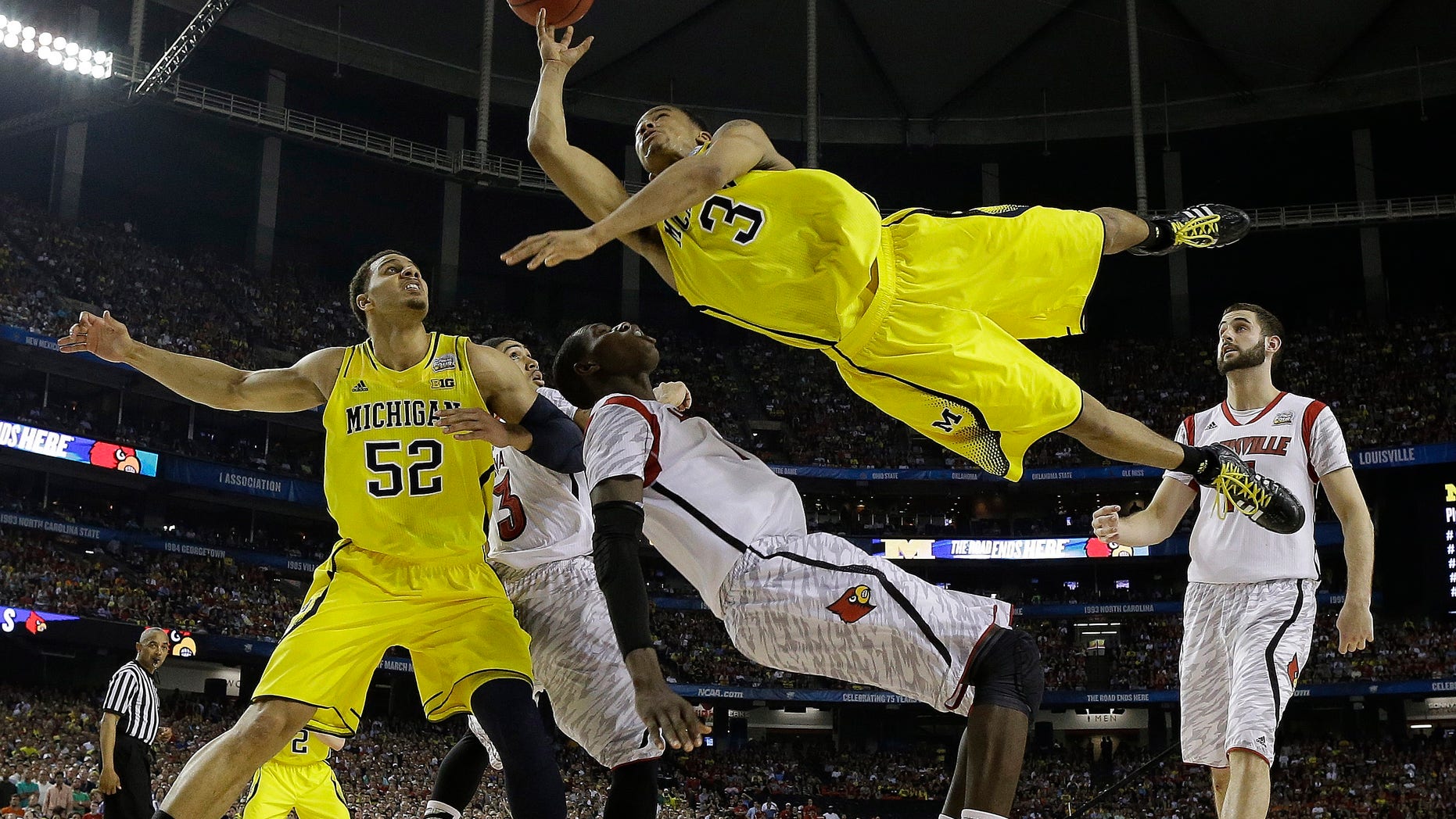 FILE - In this April 8, 2013 file photo, Michigan guard Trey Burke (3) shoots over Louisville center Gorgui Dieng (10) during the second half of the NCAA Final Four tournament college basketball championship game in Atlanta. Burke is honored as the Wooden Award winner Friday April 12, 2013 in Los Angeles. (AP Photo/Charlie Neibergall, File)