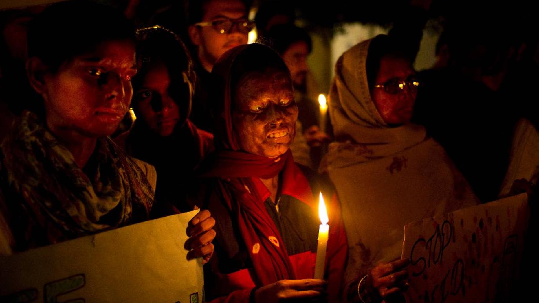 FILE - In this Dec. 16, 2014 file photo, acid attack survivors participate in a candlelit vigil protesting violence against women as they mark the second anniversary of the deadly gang rape of a student on a bus, in New Delhi, India. An Indian court has on Thursday, Sept. 8, 2016, sentenced a man to death for killing his 23-year-old woman neighbor by throwing sulfuric acid at her for refusing to marry him three years ago. This is the first death punishment for an acid attack under stringent laws framed by the government to curb crimes against women following a fatal gang rape of a young woman in a moving bus in New Delhi in 2012. (AP Photo/Saurabh Das, File)