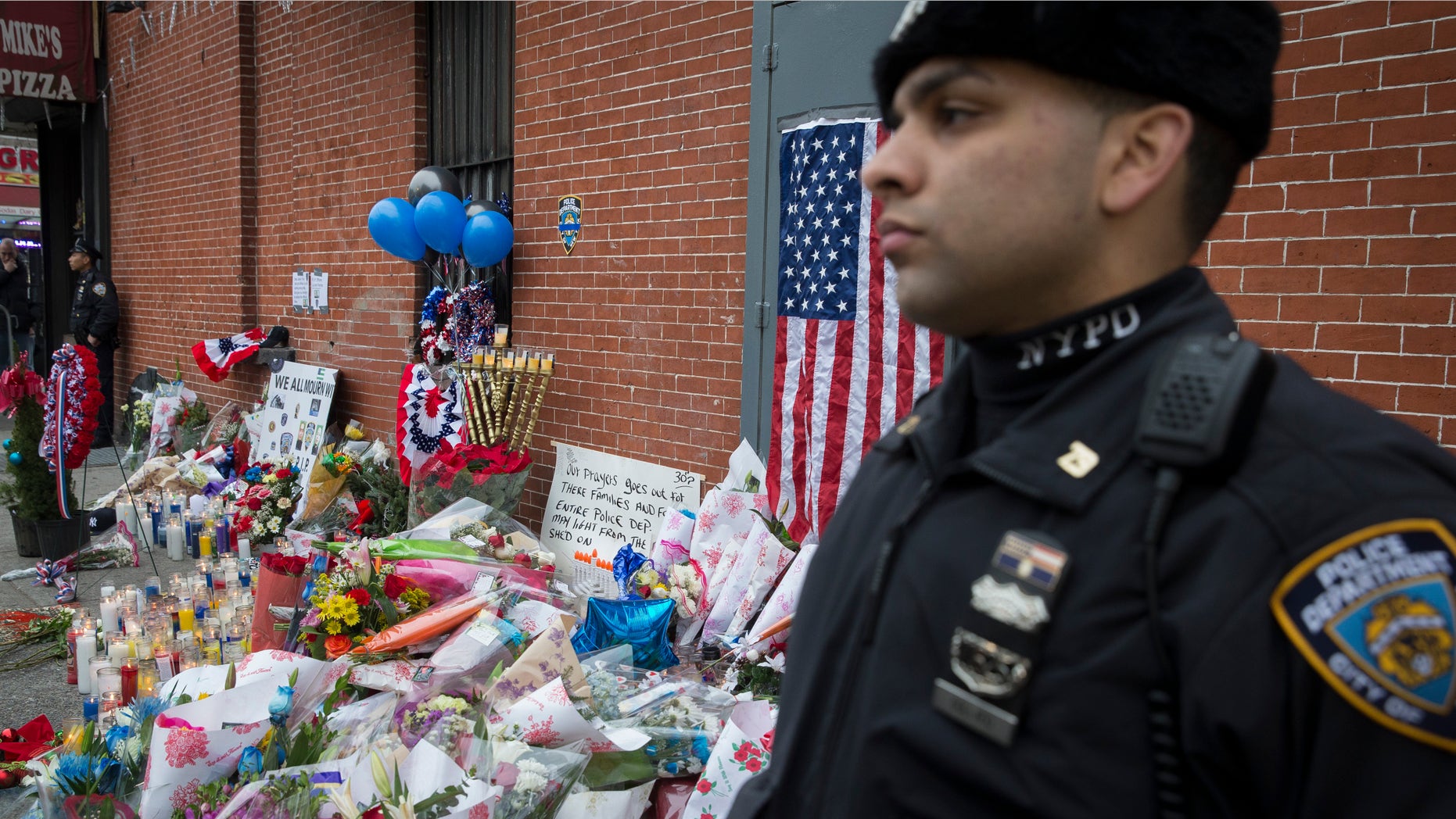 Dec. 22, 2014: A New York Police Department officer stands guard beside a makeshift memorial.