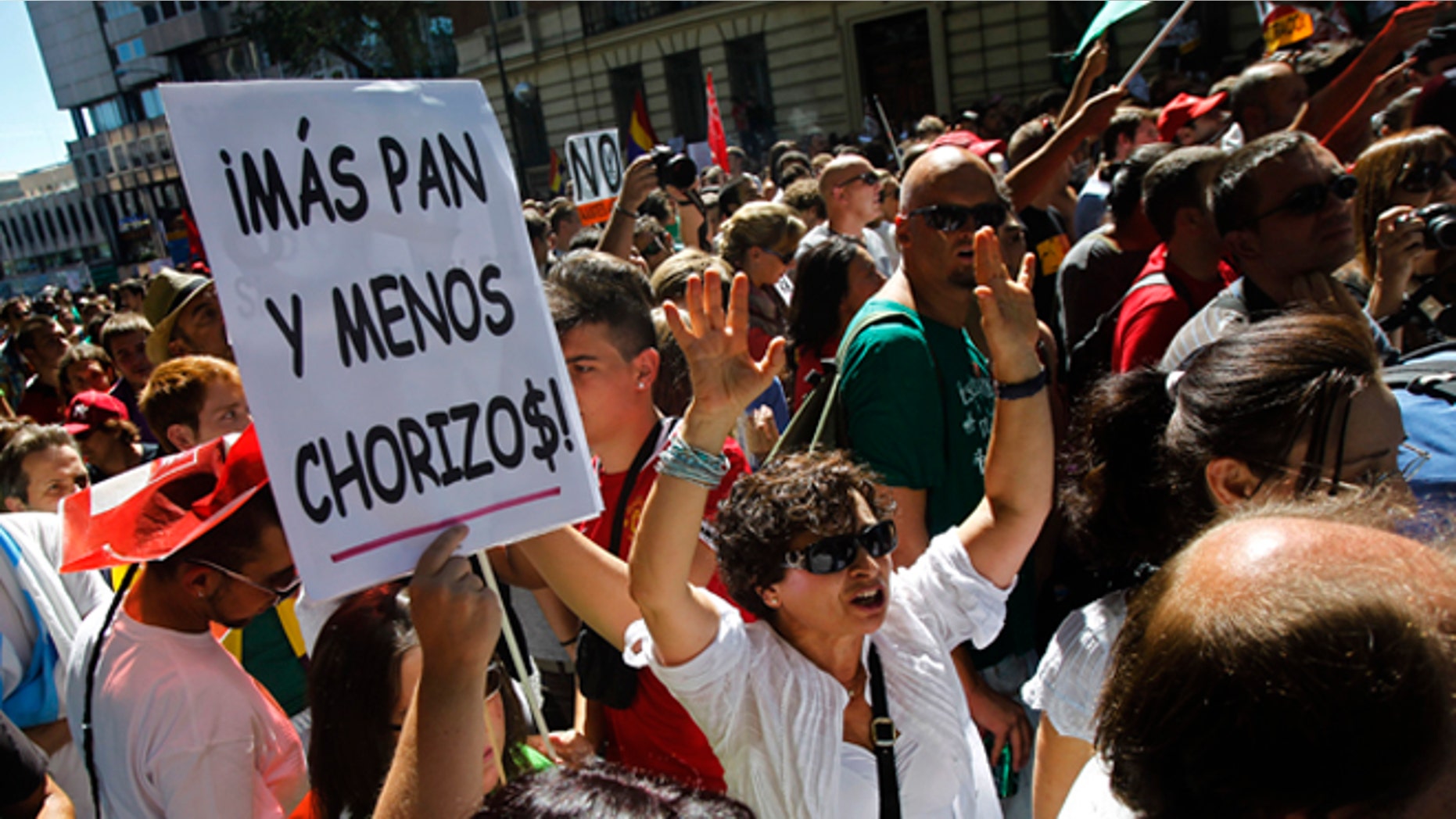 People shout slogans and show a banner reading "more bread and less thieves" protest against austerity measures applied by the Spanish government, in Columbus Square in Madrid, Spain, Saturday, Sept. 15, 2012. Tens of thousands of people from all over the country converged on Madrid to hold a large anti-austerity demonstration on Saturday. By mid-morning several major roads had been blocked as buses unloaded protesters at 10 rendezvous points from which marches began. The demonstration was called to protest government cuts during the country's financial crisis. (AP Photo/Andres Kudacki)