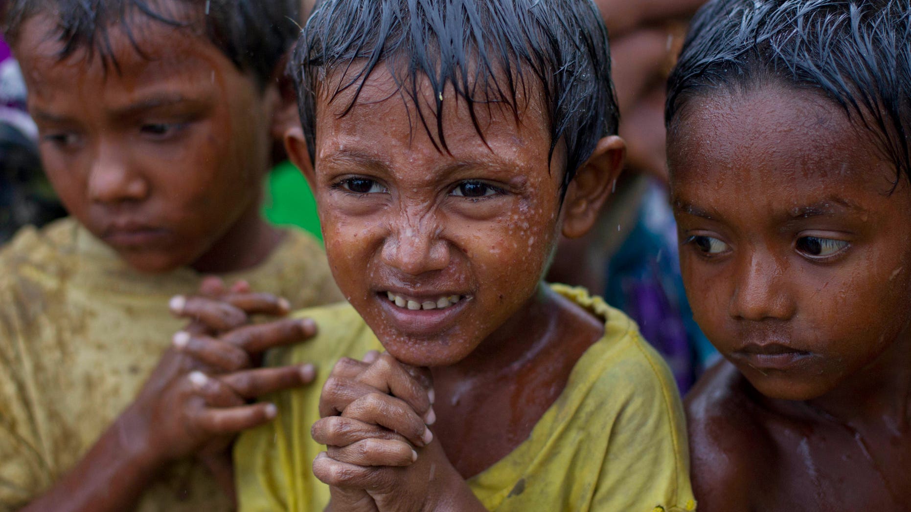 May 14, 2013: Internally displaced Rohingya boys shiver in rain in a makeshift camp for Rohingya people in Sittwe, northwestern Rakhine State, Burma, ahead of the arrival of Cyclone Mahasen.