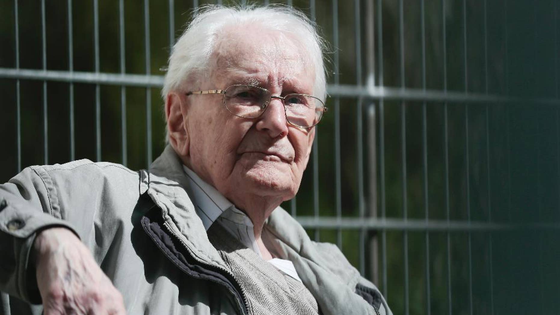Former SS guard Oskar Groening sits in ths sun during the noon break of the trial against him in Lueneburg, northern Germany, Tuesday, April 21, 2015. 93-years-old Groening faces 300,000 counts of accessory to murder at the trial, which will test the argument that anyone who served as a guard at a Nazi death camp was complicit in what happened there. Groening said he bears a share of the moral guilt for atrocities at the camp, but told judges it is up to them to decide whether he deserves to be convicted as an accessory to murder. (AP Photo/Markus Schreiber)