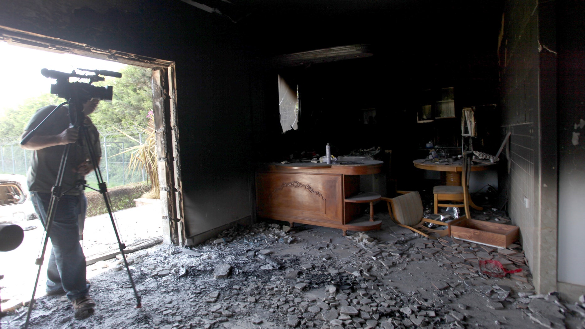 FILE - This Sept. 13, 2012 file photo shows a cameraman filming one of U.S. consulate burnt out offices after an attack that killed four Americans, including Ambassador Chris Stevens on the night of Tuesday, Sept. 11, 2012, in Benghazi, Libya. The U.S. has identified five men they believe might be behind the attack on the diplomatic mission in Benghazi, Libya, last year, and have enough evidence to justify seizing them by military force as suspected terrorists _ but not enough proof to try them in a U.S. civilian criminal court, the process the Obama administration prefers, U.S. officials said. (AP photo/Mohammad Hannon, File)