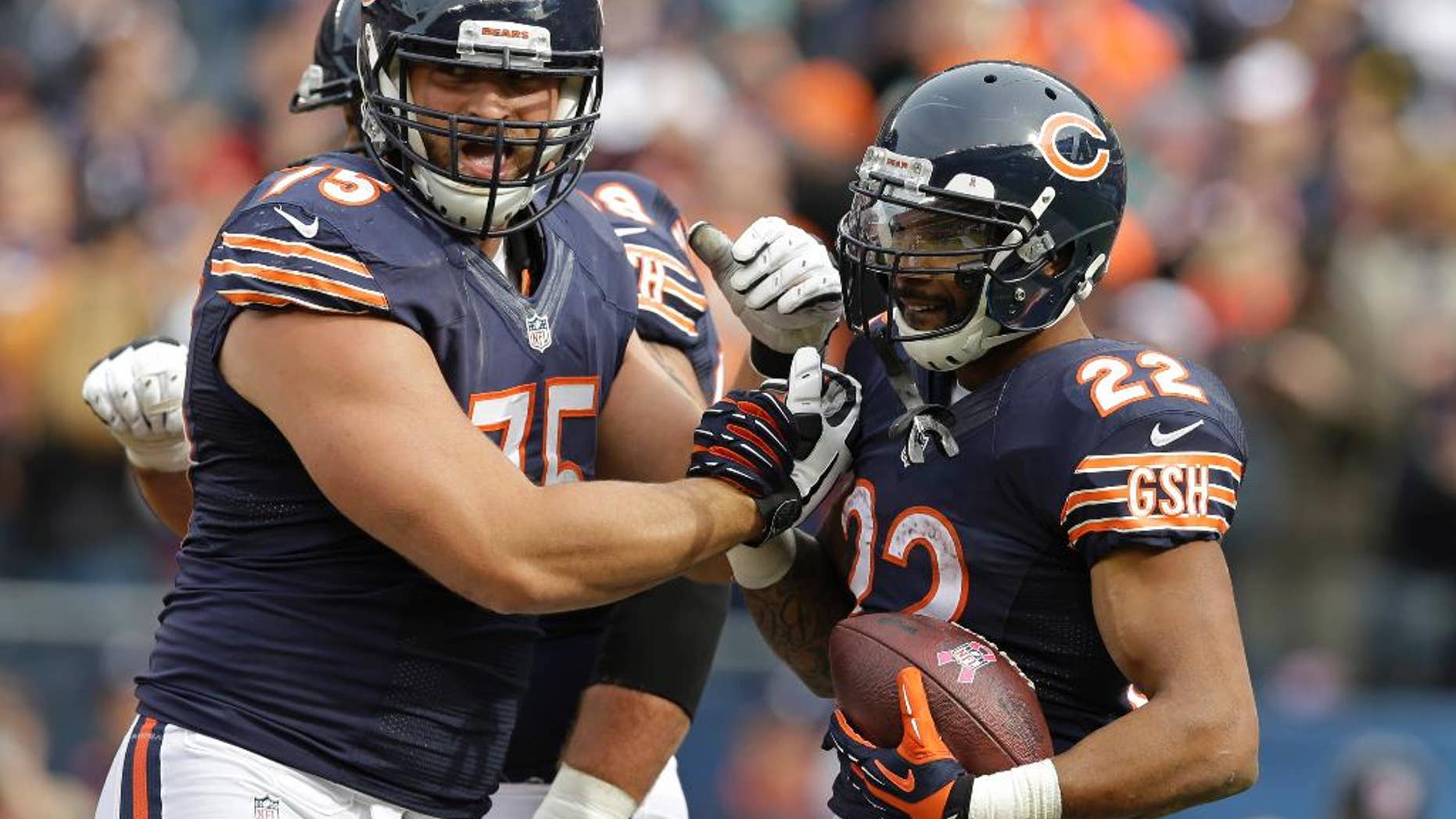 Chicago Bears running back Matt Forte (22) celebrates a touchdown with guard Kyle Long (75) during the second half of an NFL football game against the Miami Dolphins Sunday, Oct. 19, 2014 in Chicago. (AP Photo/Nam Y. Huh)