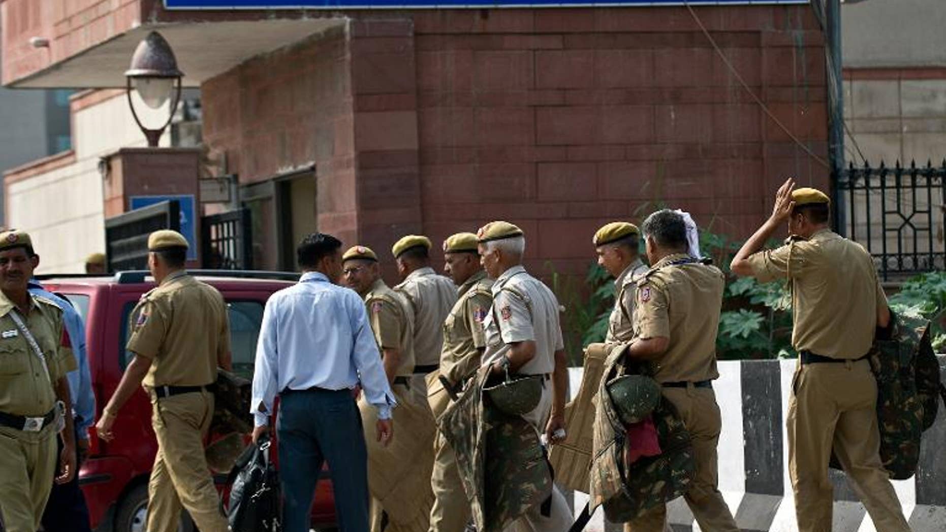 Indian police personnell carry riot gear at the Saket court complex in New Delhi on September 13, 2013