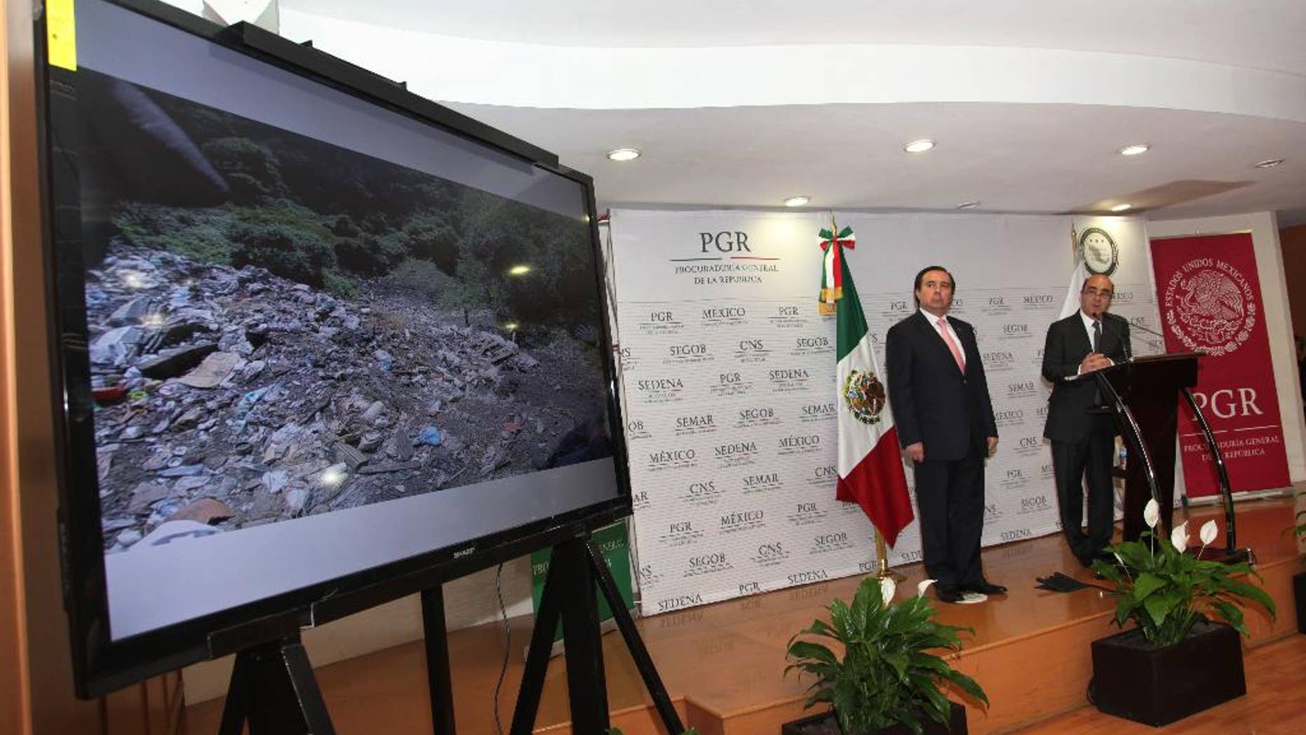 FILE - In this Dec. 7, 2014, file photo, Mexico's Attorney General, Jesus Murillo Karam, right, flanked by Tomas Zeron director of Mexico's Criminal Investigation Agency, speaks during a news conference in Mexico City. The Attorney General’s Office has announced on Wednesday, Sept. 14, 2016, the resignation of Tomas Zeron, whose dismissal had been demanded by the families of 43 college students who disappeared two years ago. (AP Photo/Marco Ugarte, File)