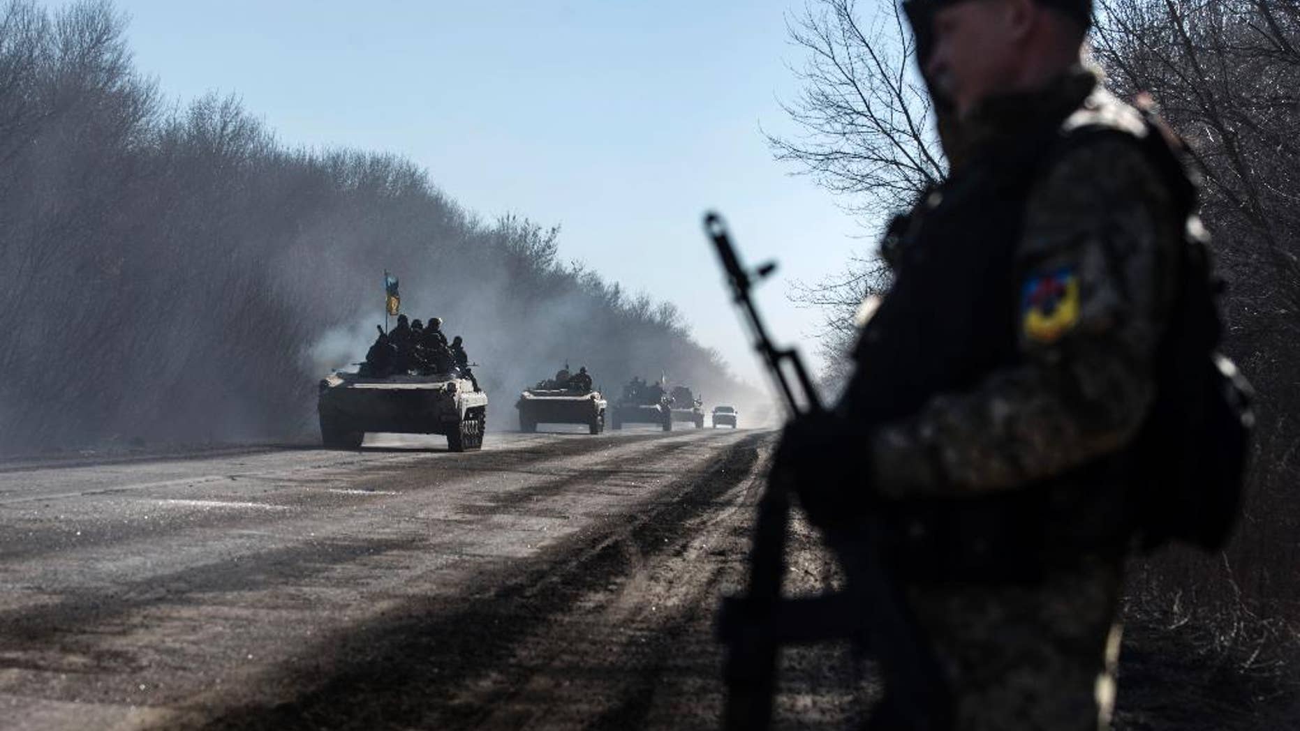 Ukrainian troops ride on armoured vehicles near Artemivsk, eastern Ukraine, Tuesday, Feb. 24, 2015. Ukrainian officials said they haven’t yet started pulling heavy weapons back from a frontline in eastern Ukraine because of continued rebel violations of a cease-fire deal. (AP Photo/Evgeniy Maloletka)