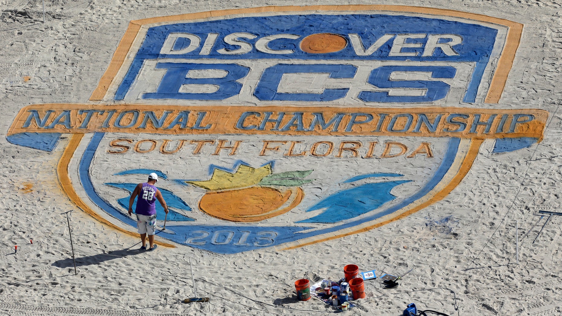 An artist puts the finishing touches on the BCS National Championship logo on the beach Sunday, Jan. 6, 2013, in Fort Lauderdale, Fla. Notre Dame takes on Alabama for the National Championship in an NCAA college football game on Monday night. (AP Photo/Chris O'Meara)