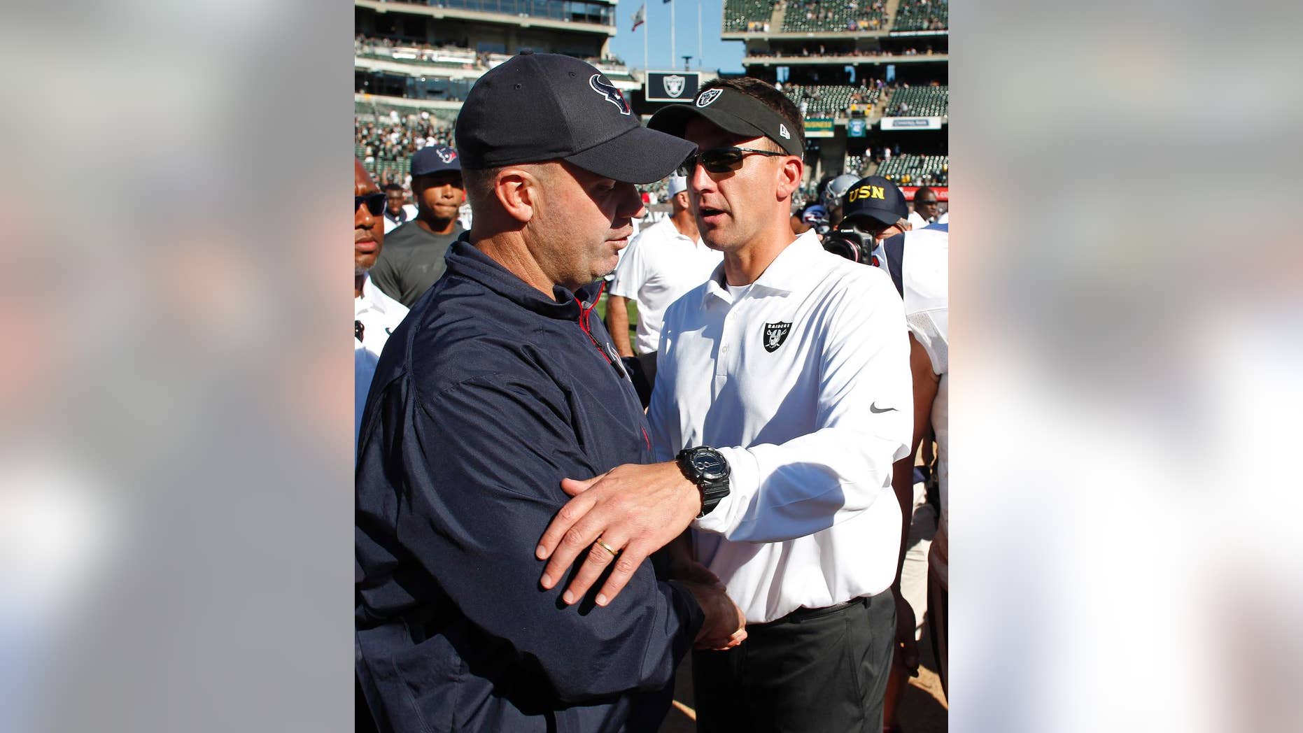 Houston Texans head coach Bill O'Brien, left, and Oakland Raiders head coach Dennis Allen, right, greet each other at the end of an NFL football game Sunday, Sept. 14, 2014, in Oakland, Calif. Houston won the game 30-14. (AP Photo/Beck Diefenbach)