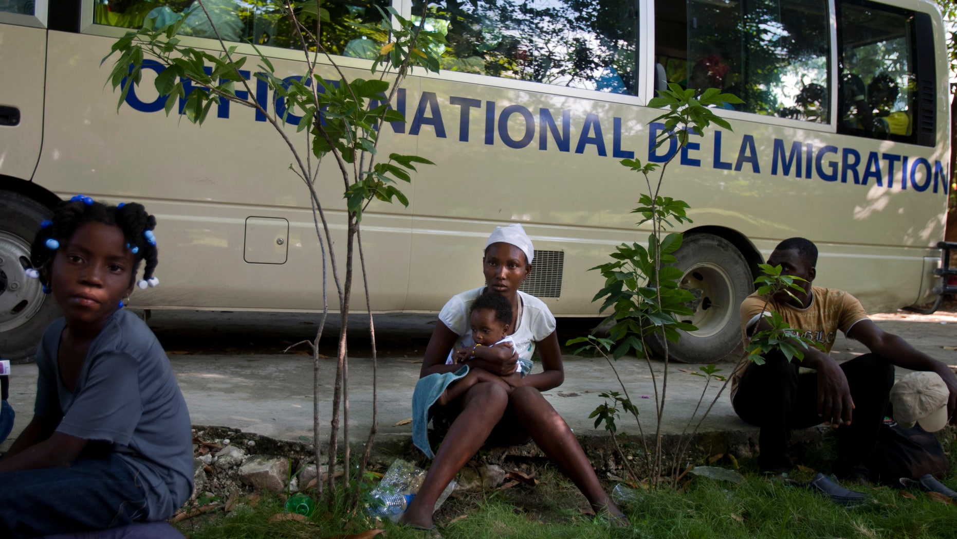 FILE - In this Nov. 24, 2013, file photo, Mona Fleurisme 20, holds her 3-month-old son Rotelson as they wait to be taken to their hometown, together with other Haitians after being deported by Dominican Republic authorities, in Croix-des-Bouquets, Haiti. Jean Baptiste Saint-Cyr, director of Haiti’s National Identification Office, has announced an effort to register Haitian immigrants, who live without documentation in the neighboring Dominican Republic as well as Turks and Caicos. (AP Photo/Dieu Nalio Chery, File)