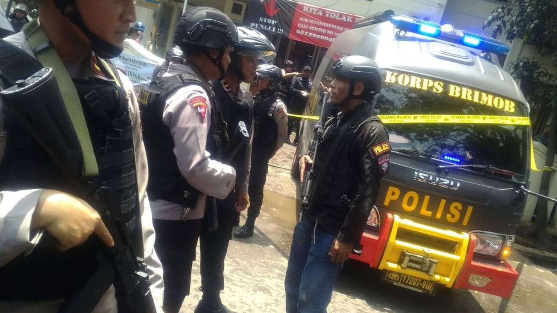 Police officers stand guard outside the municipal building after a stand off between a suspected militant and anti-terror police in Bandung, West Java, Indonesia, Monday, Feb. 27, 2017. Indonesian police say they shot the suspected militant in the West Java capital after his bomb exploded in a vacant lot and he fled into the municipal building and set it alight. (AP Photo/Khairizal Maris)