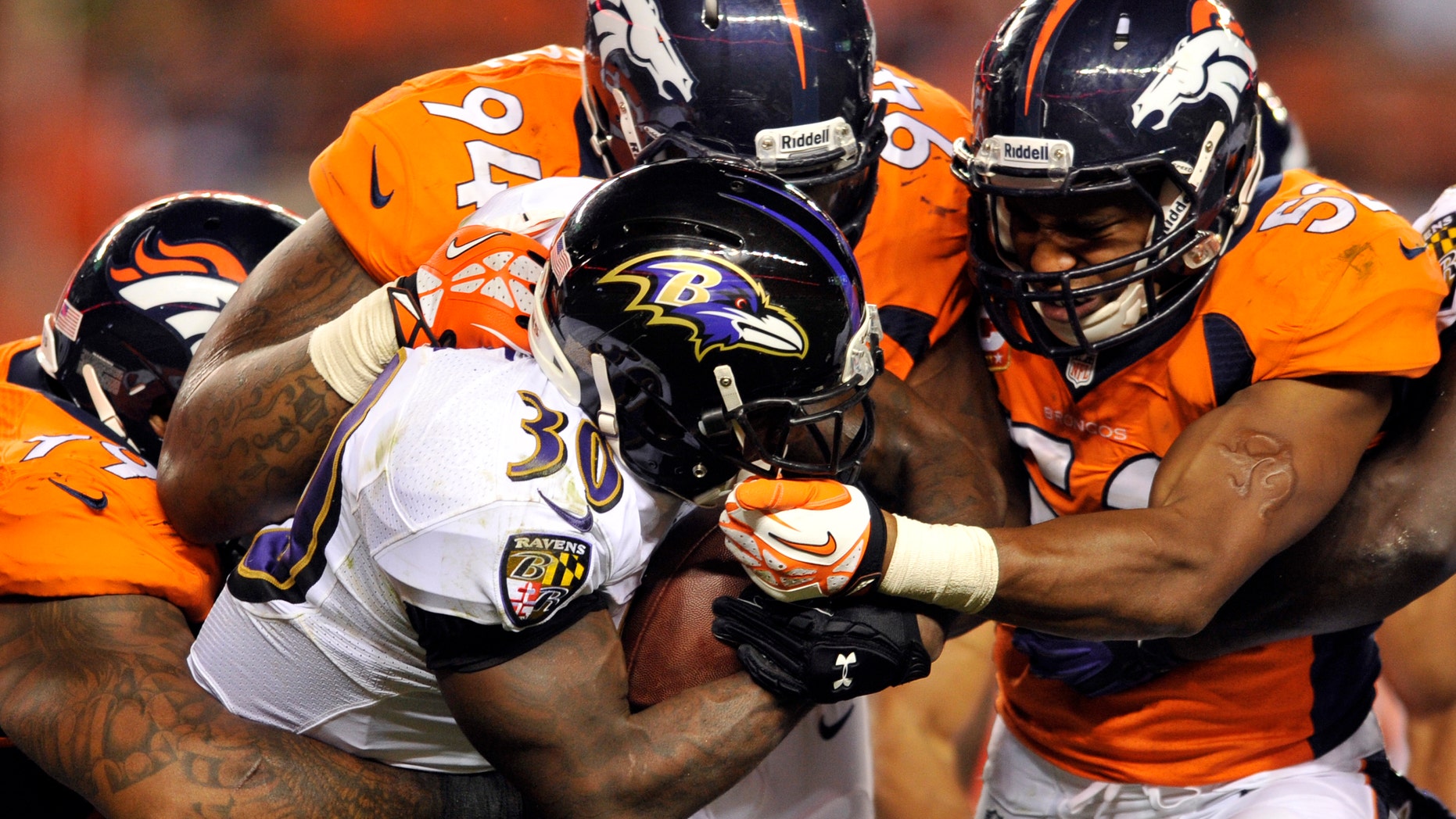 FILE - In this Sept. 25, 2013 file photo, Baltimore Ravens running back Bernard Pierce (30) is gang tackled by Denver Broncos defensive tackle Kevin Vickerson (99) , Terrance Knighton (94) and Wesley Woodyard (52) during an NFL football game, in Denver. Increasingly, teams are having trouble getting what they need on the ground on third or fourth down, with 2 or fewer yards needed for a first down or a touchdown. And increasingly, they're trying to pass for those short gains. (AP Photo/Jack Dempsey, File)