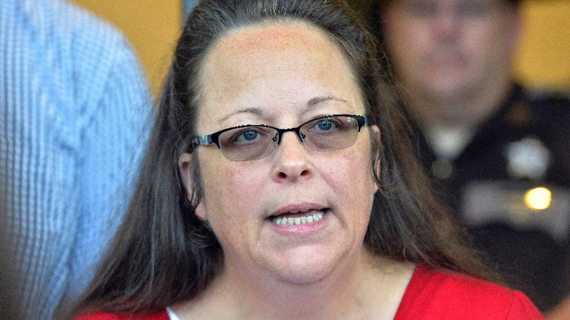 Rowan County Clerk Kim Davis makes a statement to the media at the front door of the Rowan County Judicial Center in Morehead, Ky., Monday, Sept. 14, 2015. Davis announced that her office will issue marriage licenses under order of a federal judge, but they will not have her name or office listed. (AP Photo/Timothy D. Easley)