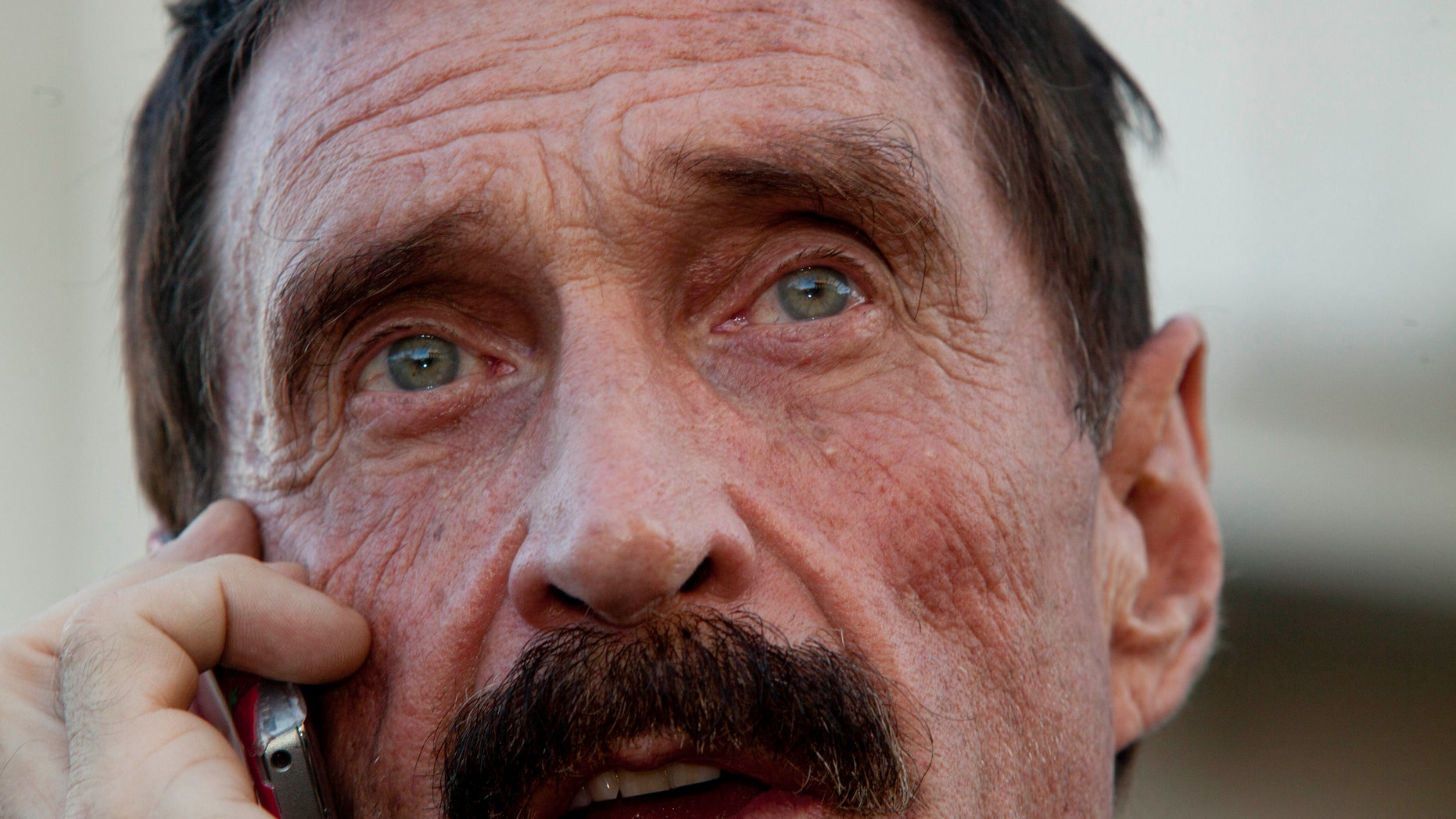 Software company founder John McAfee, here in a 2012 file photo, says his "enemies" spiked something he ingested.