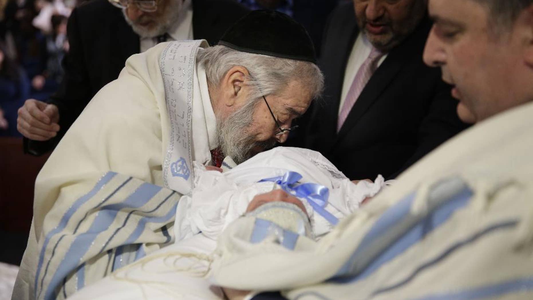FILE- In this Feb. 11, 2015 file photo, Abraham Romi Cohn performs the oral suction during the bris, or ritual circumcision, of Yosef Sananas in New York. Reversing a policy that pitted health officials against religious leaders over a practice that dates to biblical times, the New York City Board of Health will no longer require parents to sign acknowledgements of potential health risks when their children undergo oral circumcision, Wednesday, Sept. 9, 2015. (AP Photo/Seth Wenig, File)