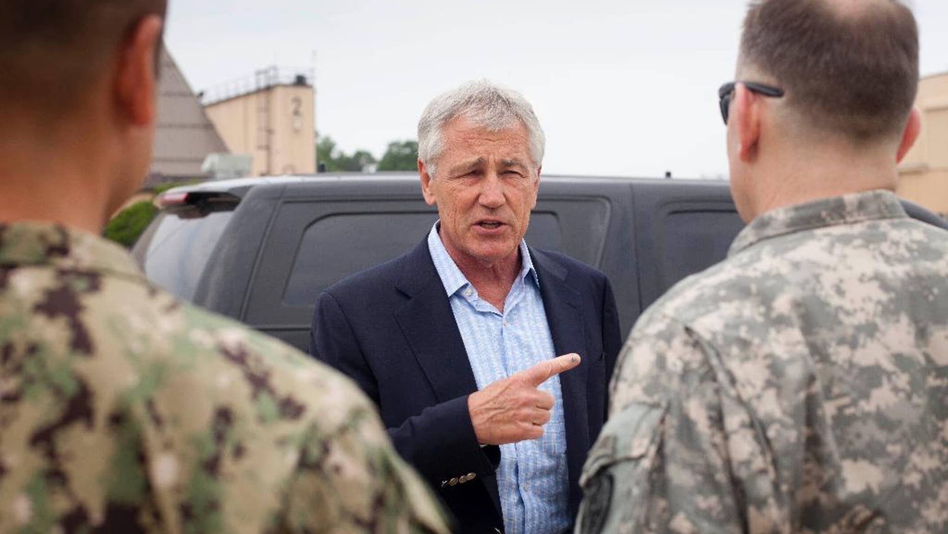 Defense Secretary Chuck Hagel speaks with members of his military staff before boarding his plane prior to his departure from Andrews Air Force Base, Md., Wednesday, May 28, 2014. Hagel is traveling on a 12-day trip to Asia and Europe, his fourteenth international trip, to discuss key regional and global issues with leaders of several countries. (AP Photo/Pablo Martinez, Pool)