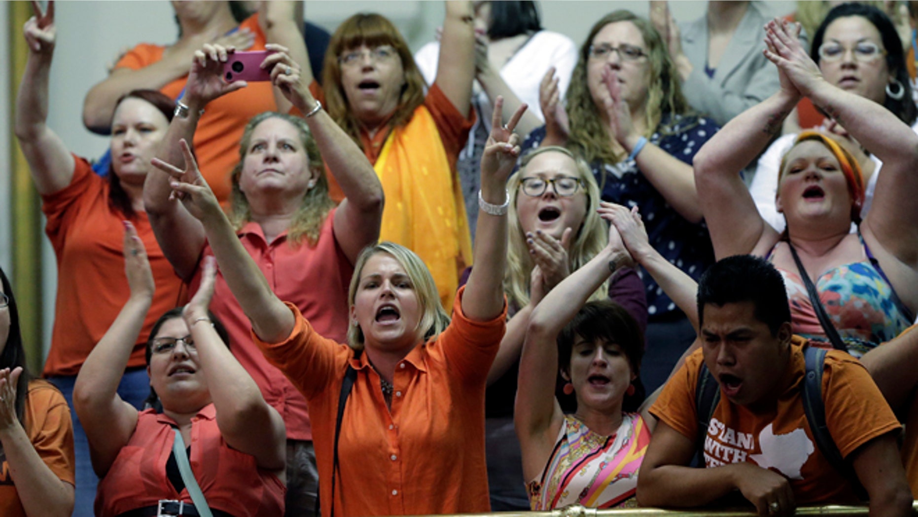 Members of the gallery cheer and chant as the Texas Senate tries to bring an abortion bill to a vote as time expires, Wednesday, June 26, 2013, in Austin, Texas. Amid the deafening roar of abortion rights supporters, Texas Republicans huddled around the Senate podium to pass new abortion restrictions, but whether the vote was cast before or after midnight is in dispute. If signed into law, the measures would close almost every abortion clinic in Texas. (AP Photo/Eric Gay)