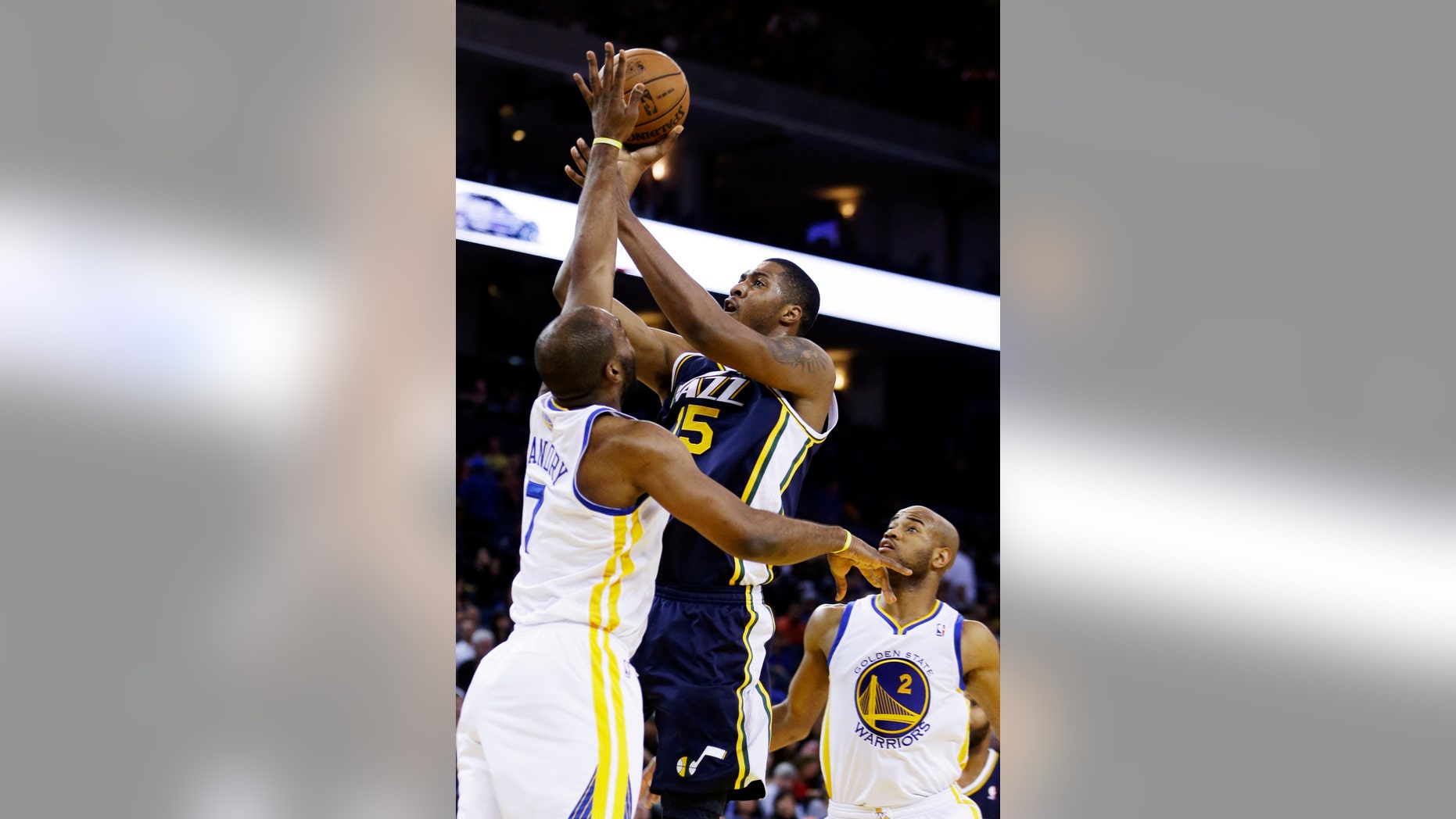 Utah Jazz's Derrick Favors (15) shoots over Golden State Warriors' Carl Landry during the first half of an NBA basketball game, Sunday, April 7, 2013, in Oakland, Calif. (AP Photo/Ben Margot)