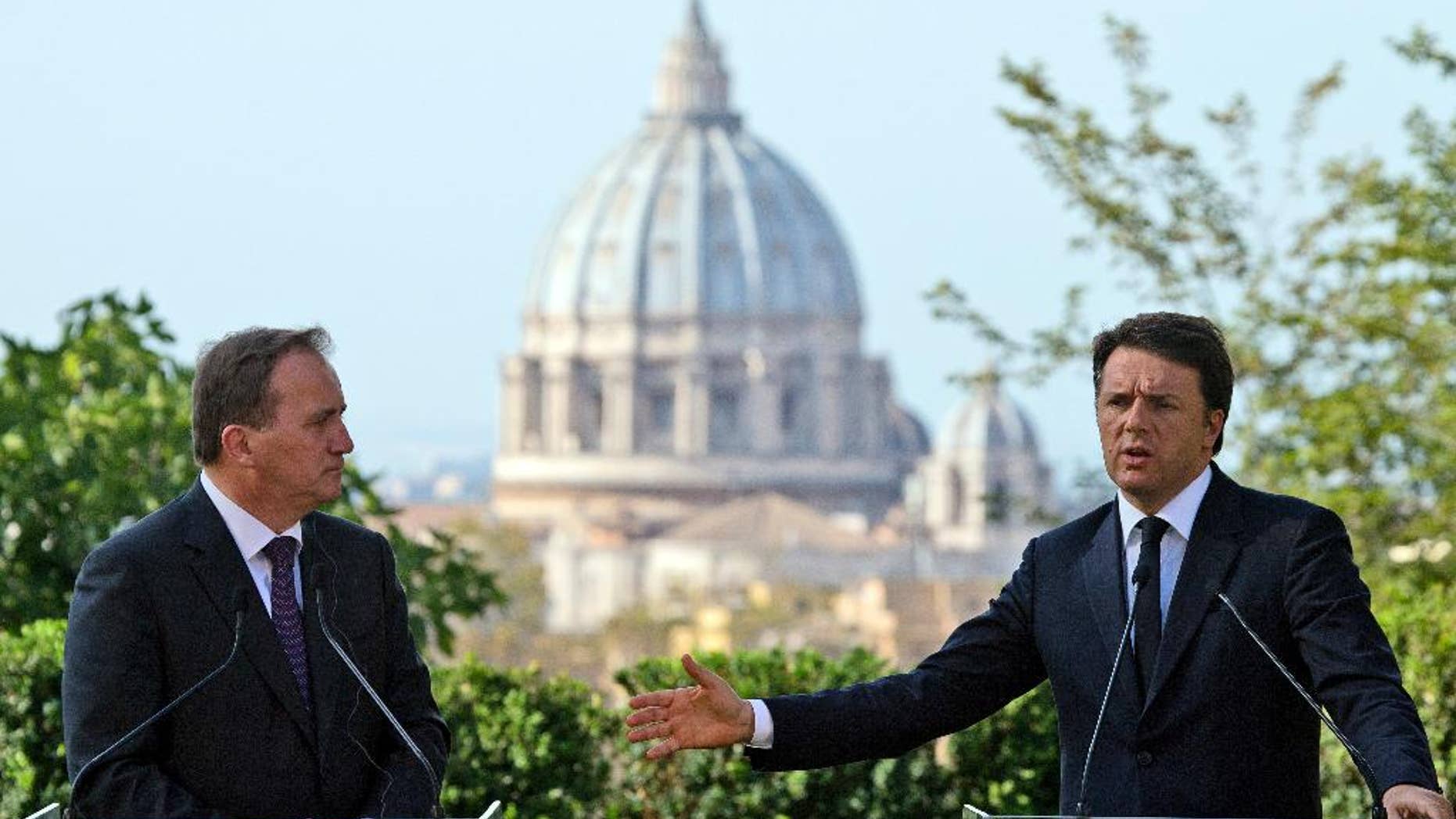 Italian Premier Matteo Renzi, right, and Swedish Prime Minister Stefan Lofven, backdropped by the St. Peter's Basilica, talk to journalists during a press conference at the end of their meeting, at Rome's Villa Panphilii, Wednesday, July 6, 2016. (AP Photo/Andrew Medichini)