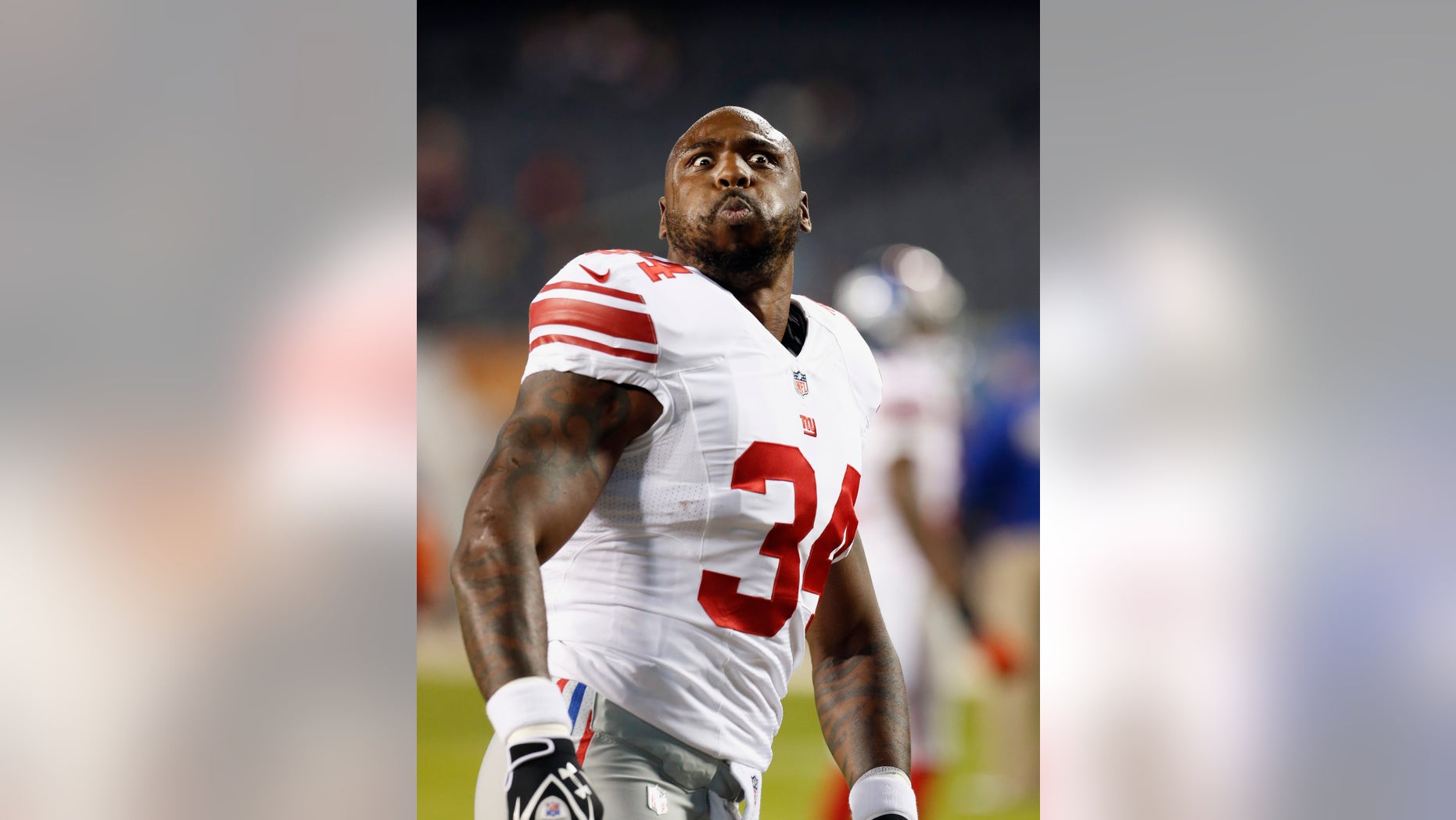 New York Giants running back Brandon Jacobs makes a face at fans before the Giants' NFL football game against the Chicago Bears, Thursday, Oct. 10, 2013, in Chicago. (AP Photo/Charles Rex Arbogast)