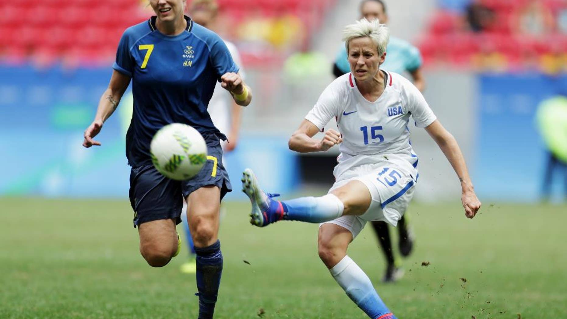 FILE - In this Friday, Aug. 12, 2016, file photo, United States' Megan Rapinoe, right, kicks the ball past Sweden's Lisa Dahlkvist during a quarterfinal match of the women's Olympic soccer tournament in Brasilia. Rapinoe knelt during the national anthem Sunday, Sept. 4, before the Seattle Reign's game against the Chicago Red Stars "in a little nod" to NFL quarterback Colin Kaepernick. (AP Photo/Eraldo Peres, File)