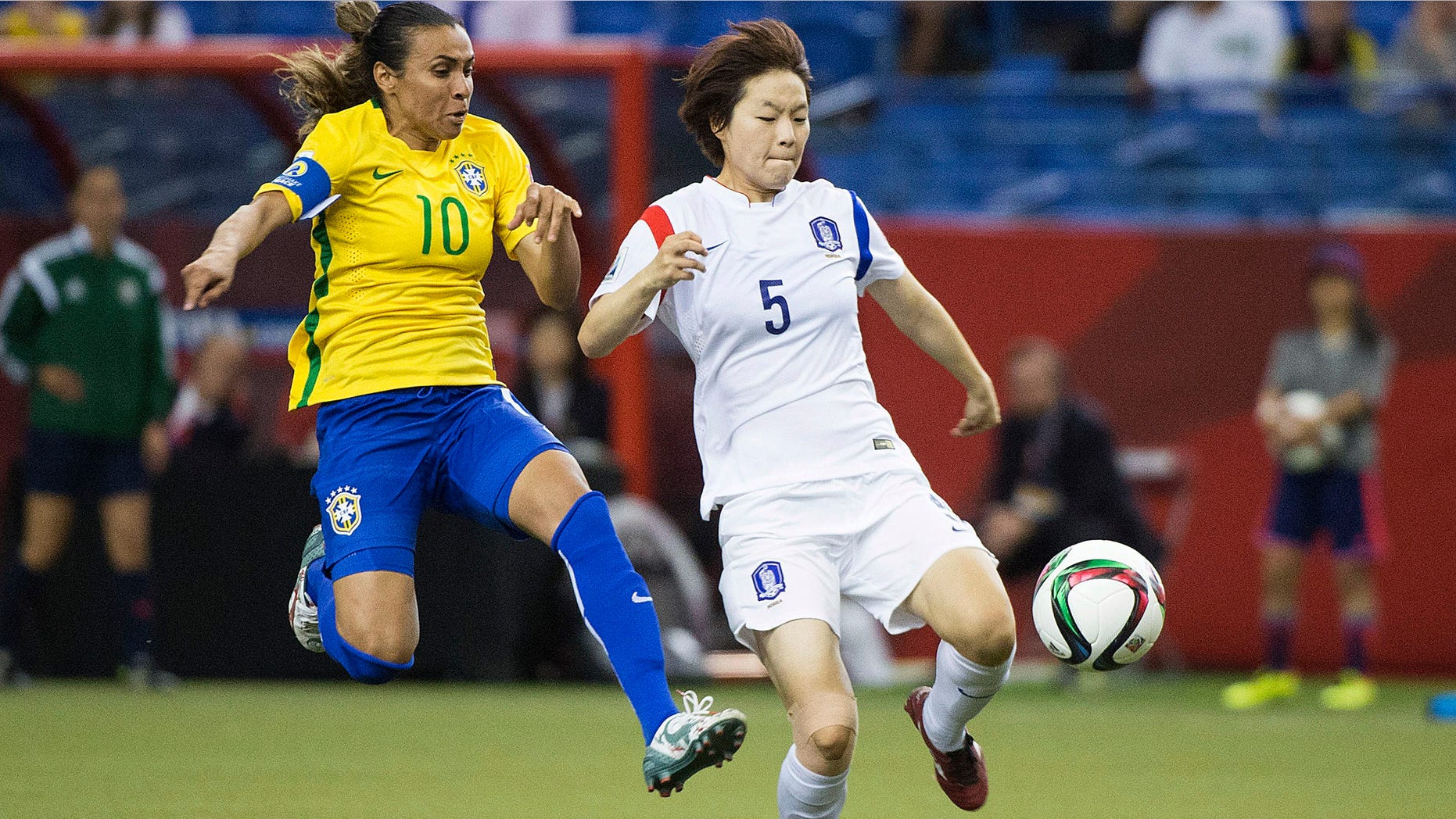Brazil's Marta (10) challenges South Korea's Kim Doyeon during the second half of a FIFA Women's World Cup soccer match Tuesday, June 9, 2015, in Montreal, Canada. (Graham Hughes/The Canadian Press via AP)