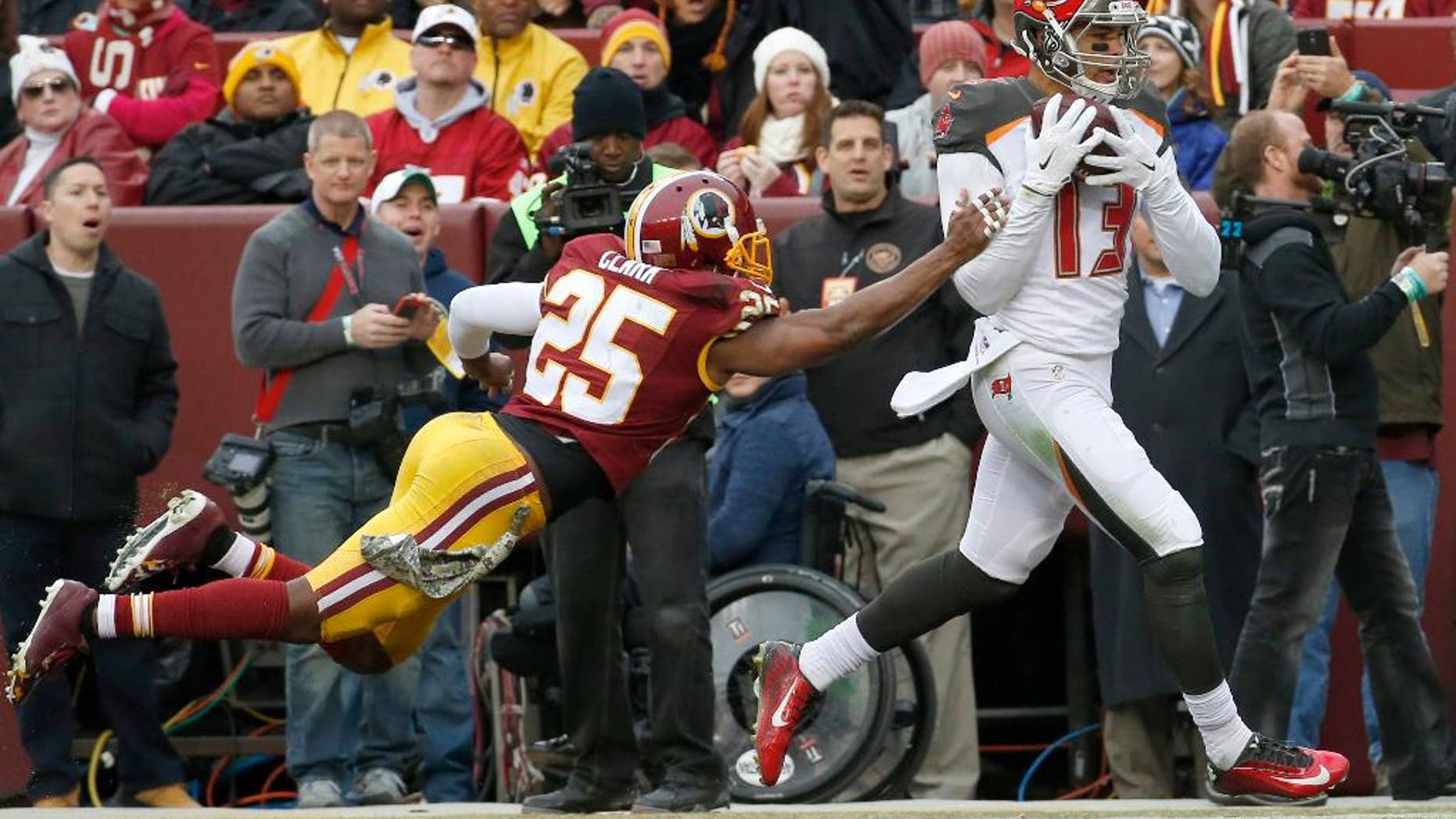 Tampa Bay Buccaneers wide receiver Mike Evans (13) pulls in a touchdown pass under pressure from Washington Redskins free safety Ryan Clark (25) during the second half of an NFL football game in Landover, Md., Sunday, Nov. 16, 2014. (AP Photo/Alex Brandon)
