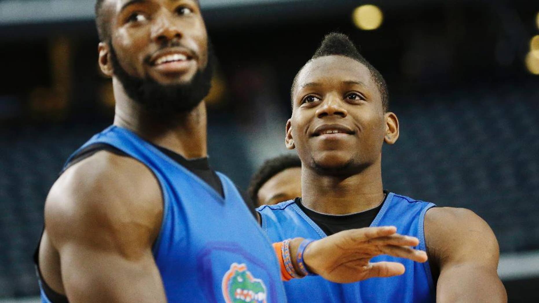 Florida center Patric Young, left, and forward Will Yeguete joke around during practice for their NCAA Final Four tournament college basketball semifinal game Friday, April 4, 2014, in Dallas. Florida plays Connecticut on Saturday, April 5, 2014. (AP Photo/David J. Phillip)