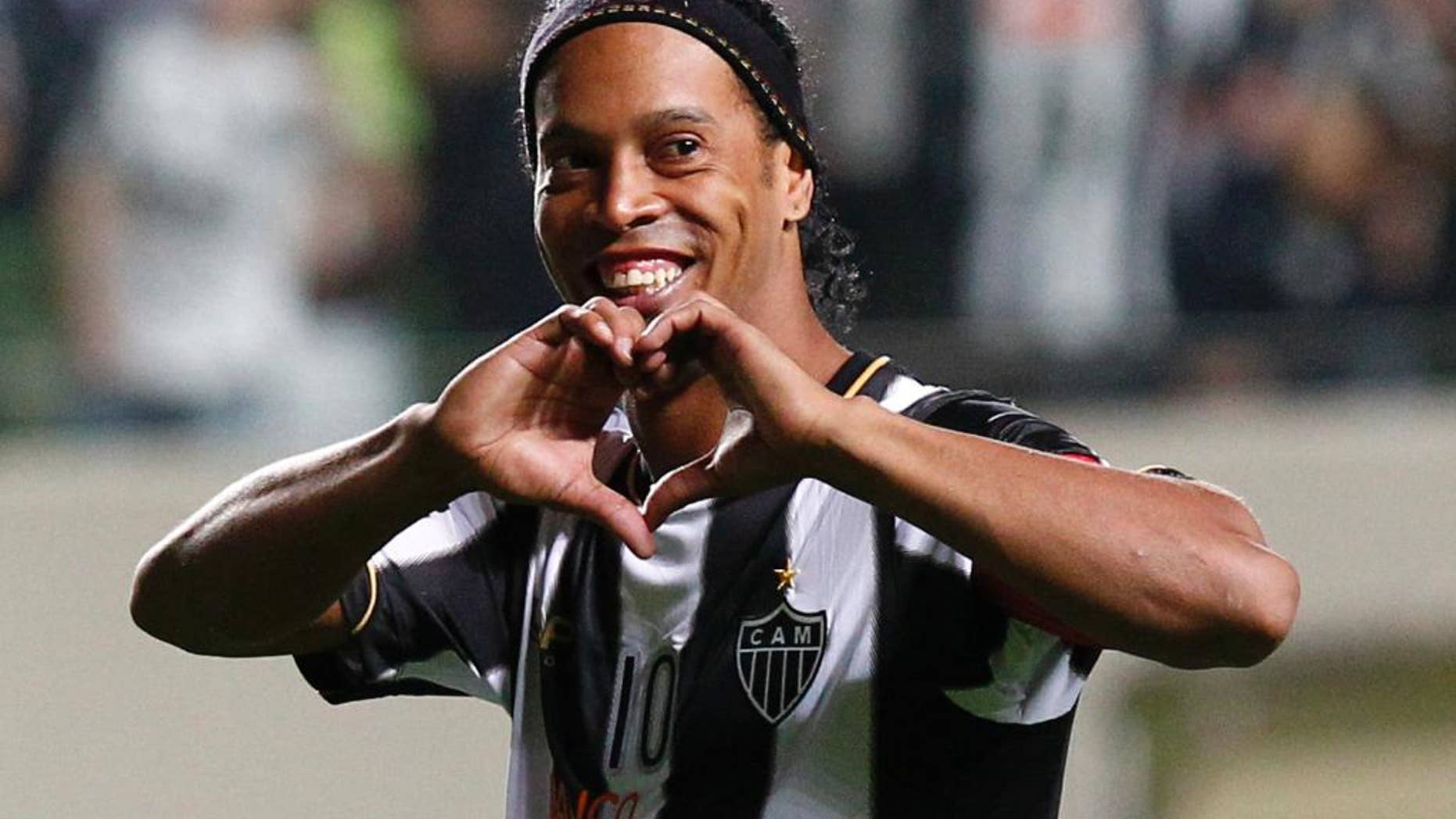 FILE - In this July 11, 2013 file photo, Brazil's Atletico Mineiro's Ronaldinho celebrates his team's victory over Argentina's Newell's Old Boys at the end of a Copa Libertadores semifinal soccer match in Belo Horizonte, Brazil. Mexico's Queretaro soccer club announced on Friday, Sept. 5, 2014 they came to an agreement with Ronaldinho for him to play on their team. (AP Photo/Bruno Magalhaes, File)