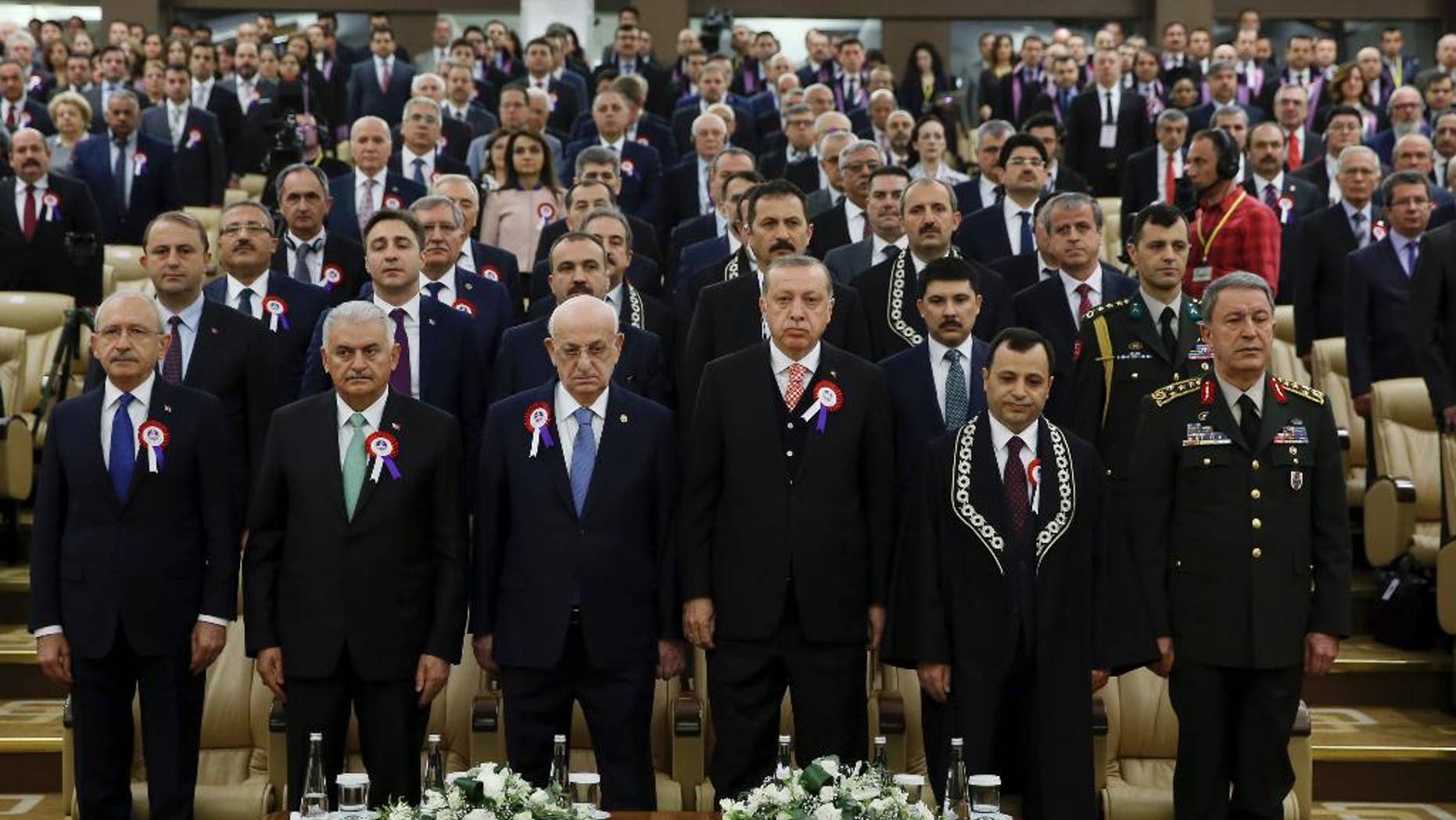 Turkey's President Recep Tayyip Erdogan, 4th left, accompanied by, from left to right, Kemal Kilicdaroglu, leader of the Republican People's Party (CHP), Prime Minister Binali Yildirim, Ismail Kahraman, Speaker of the Grand National Assembly of Turkey, Turkish Constitutional Court Chairman Zuhtu Arslan and Chief of the General Staff of the Turkish Armed Forces, Hulusi Akar, attend a ceremony as part of the 55th anniversary of the founding of Turkey's Constitutional Court, in Ankara, Turkey, on Tuesday, April 25, 2017. Legislators representing Europe's top human rights body, the Strasbourg-France-based Parliamentary Assembly of the Council of Europe, on Tuesday voted in favour of re-opening monitoring procedures in Turkey in a move that reflects its strong concern over the functioning of democratic institutions in the country.(Press Presidency Press Service Pool Photo via AP)