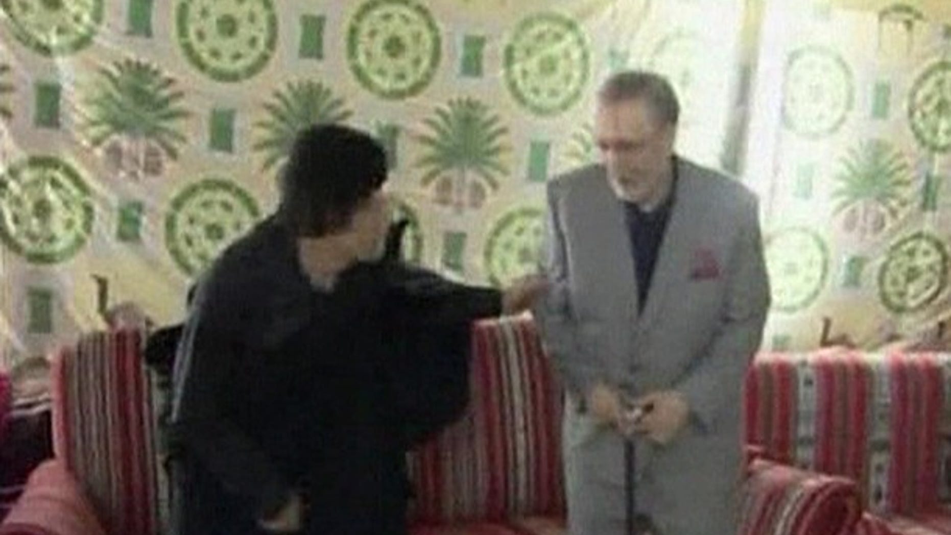 Convicted Lockerbie bomber Abdel Basset al-Megrahi (R) sits with Libyan leader Muammar Gaddafi in Tripoli in this August 21, 2009 video grab from Libya TV. Gaddafi hugged the convicted Lockerbie bomber and promised more cooperation with Britain in gratitude for his release, while London and Washington condemned his "hero's welcome" home. Meeting Megrahi and his family late on Friday, Gaddafi thanked British Prime Minister Gordon Brown and Queen Elizabeth for "encouraging" Scotland to release the dying prisoner from a Scottish jail, Libyan news agency JANA reported. REUTERS/Libya TV via REUTERS TV (LIBYA POLITICS CONFLICT) NO SALES. NO ARCHIVES. FOR EDITORIAL USE ONLY. NOT FOR SALE FOR MARKETING OR ADVERTISING CAMPAIGNS. LIBYA OUT. NO COMMERCIAL OR EDITORIAL SALES IN LIBYA