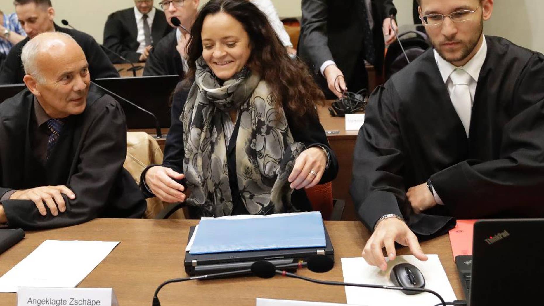 Terror suspect Beate Zschaepe arrives at the court room besides her lawyers Hermann Borchert, left, and Mathias Grasel in Munich, Germany, Thursday, Sept. 29, 2016. Zschaepe is accused of being involved in 10 neo-Nazi murders of the National Socialist Underground group, which allegedly killed eight Turkish men, a Greek and a policewoman between 2000 and 2007. (AP Photo/Matthias Schrader)