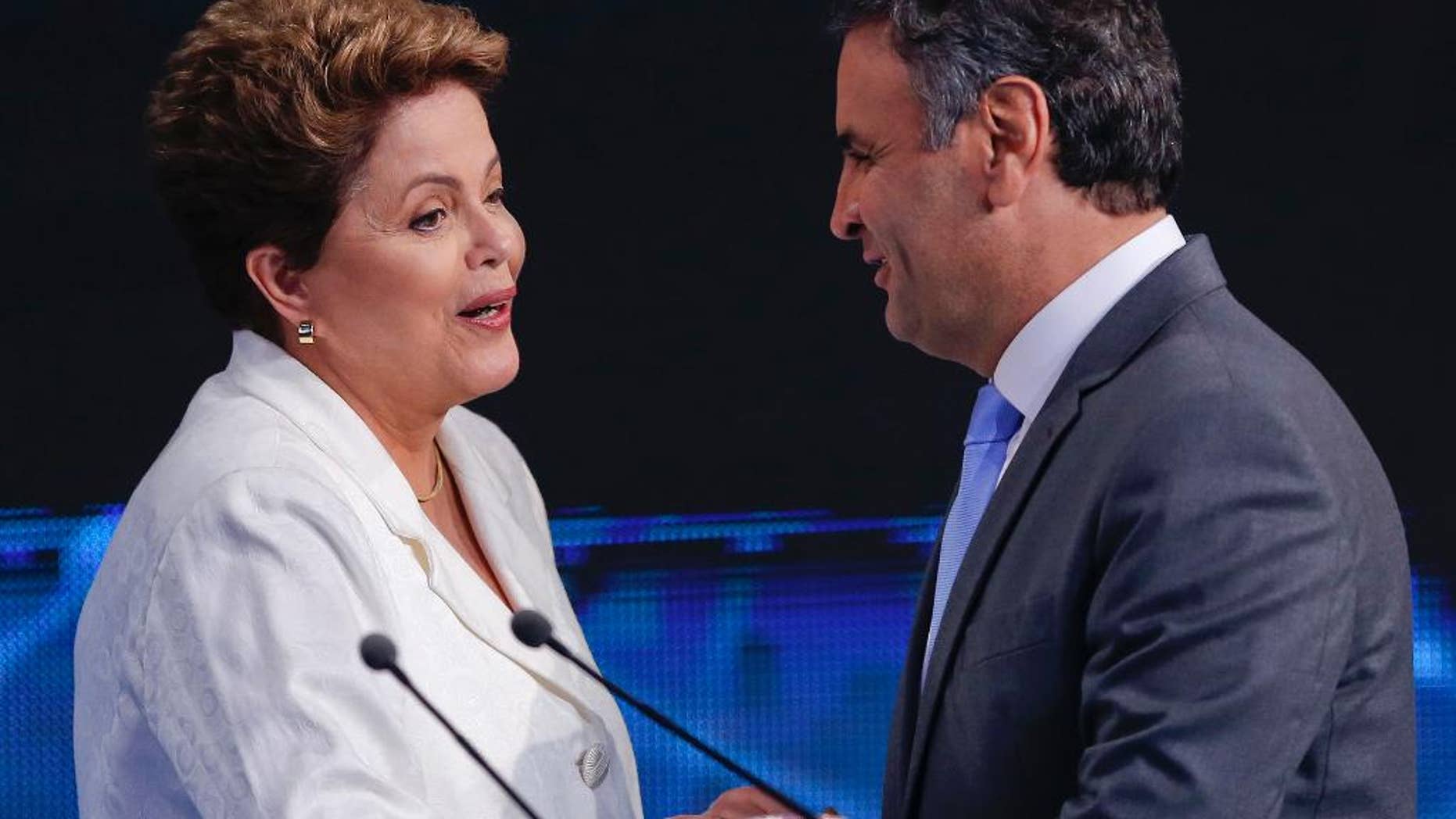 Brazil's President Dilma Rousseff, presidential candidate for re-election of the Workers Party, PT , left, shakes hands with Aecio Neves, presidential candidate of the Brazilian Social Democracy Party, PSDB, at the end of a presidential debate in Sao Paulo, Brazil, Tuesday, Oct. 14, 2014. Rousseff and Neves will face each other in a presidential runoff on Oct. 26. (AP Photo/Andre Penner)