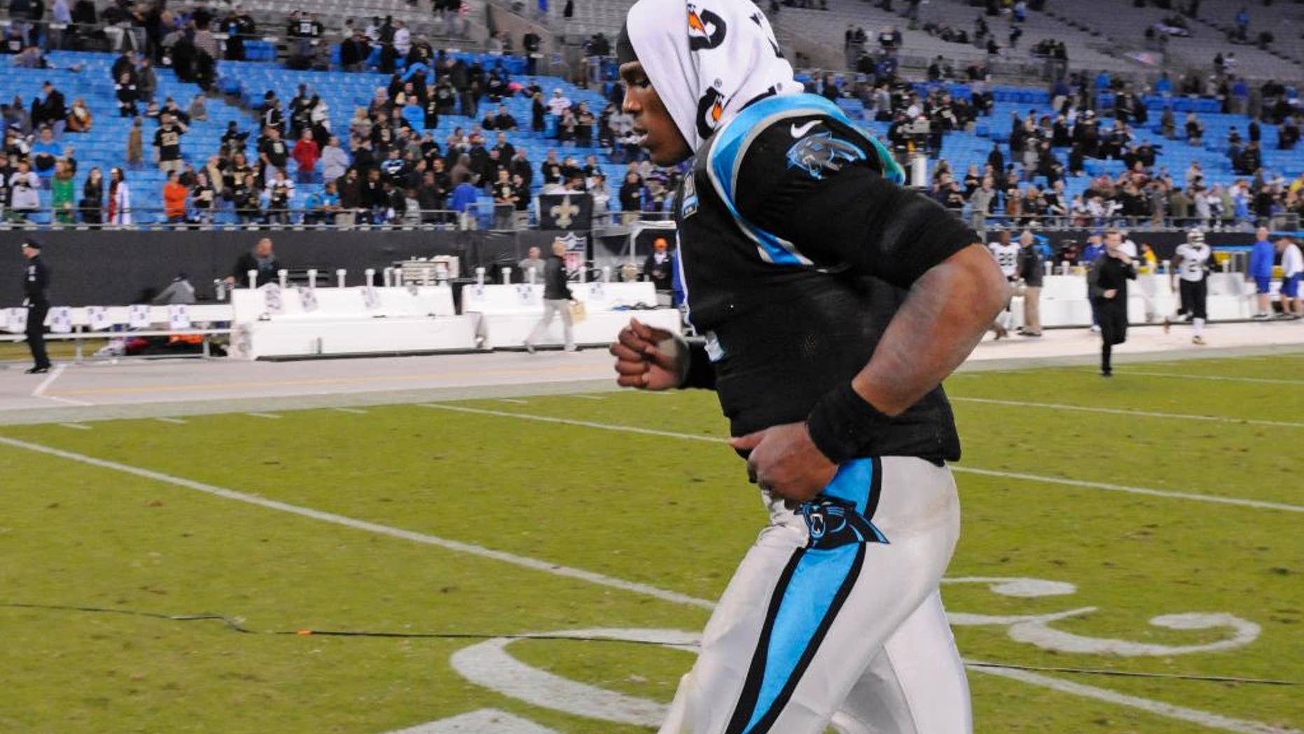 Carolina Panthers' Cam Newton (1) runs off the field after an NFL football game against the New Orleans Saints in Charlotte, N.C., Thursday, Oct. 30, 2014. The Saints won 28-10. (AP Photo/Mike McCarn)
