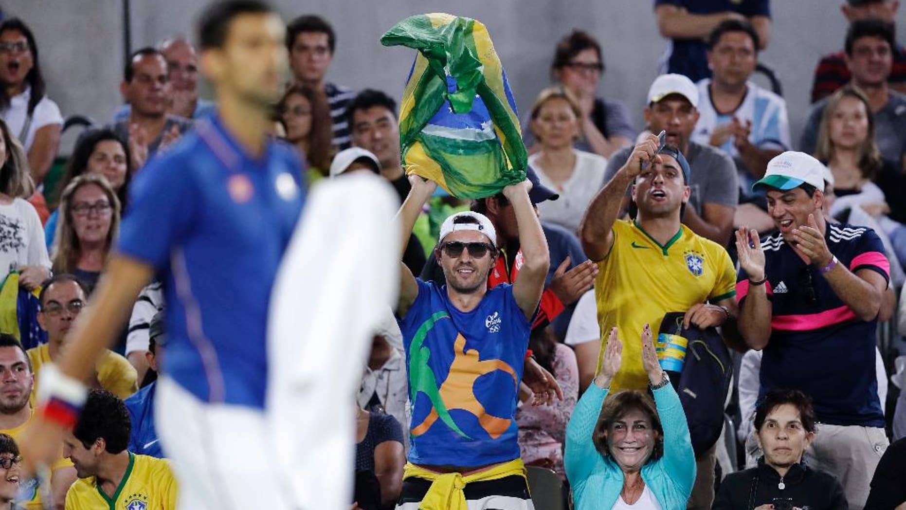 Fans cheer for Novak Djokovic, of Serbia, during his match against Juan Martin del Potro, of Argentina, at the 2016 Summer Olympics in Rio de Janeiro, Brazil, Sunday, Aug. 7, 2016. (AP Photo/Charles Krupa)